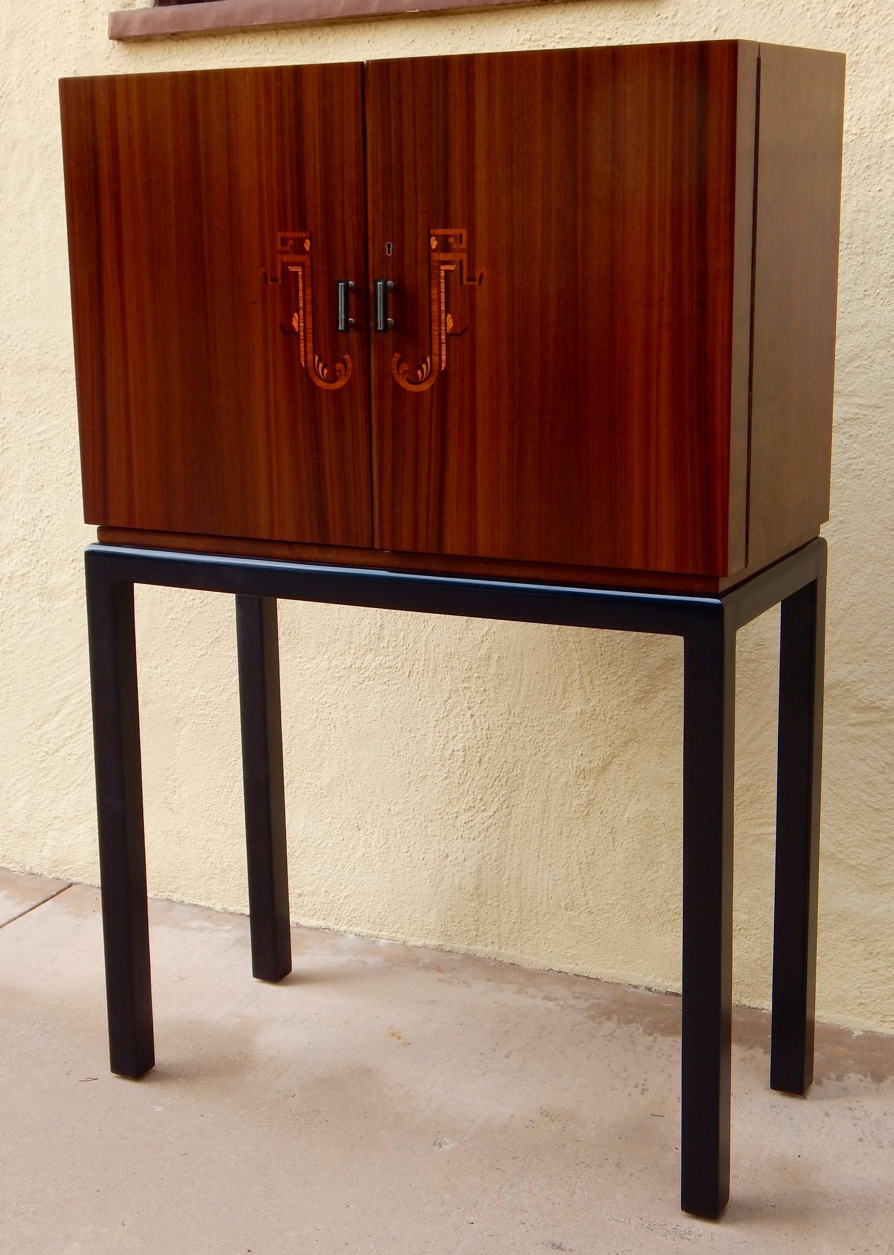 Swedish Art Deco inlaid dry bar or Secrétaire rendered in walnut, and birch wood. Inlaid rosewood, birch and ebony. Base in ebonized birch. Interior in golden birch wood and highly figured walnut. Interior perfectly sized to house approximately