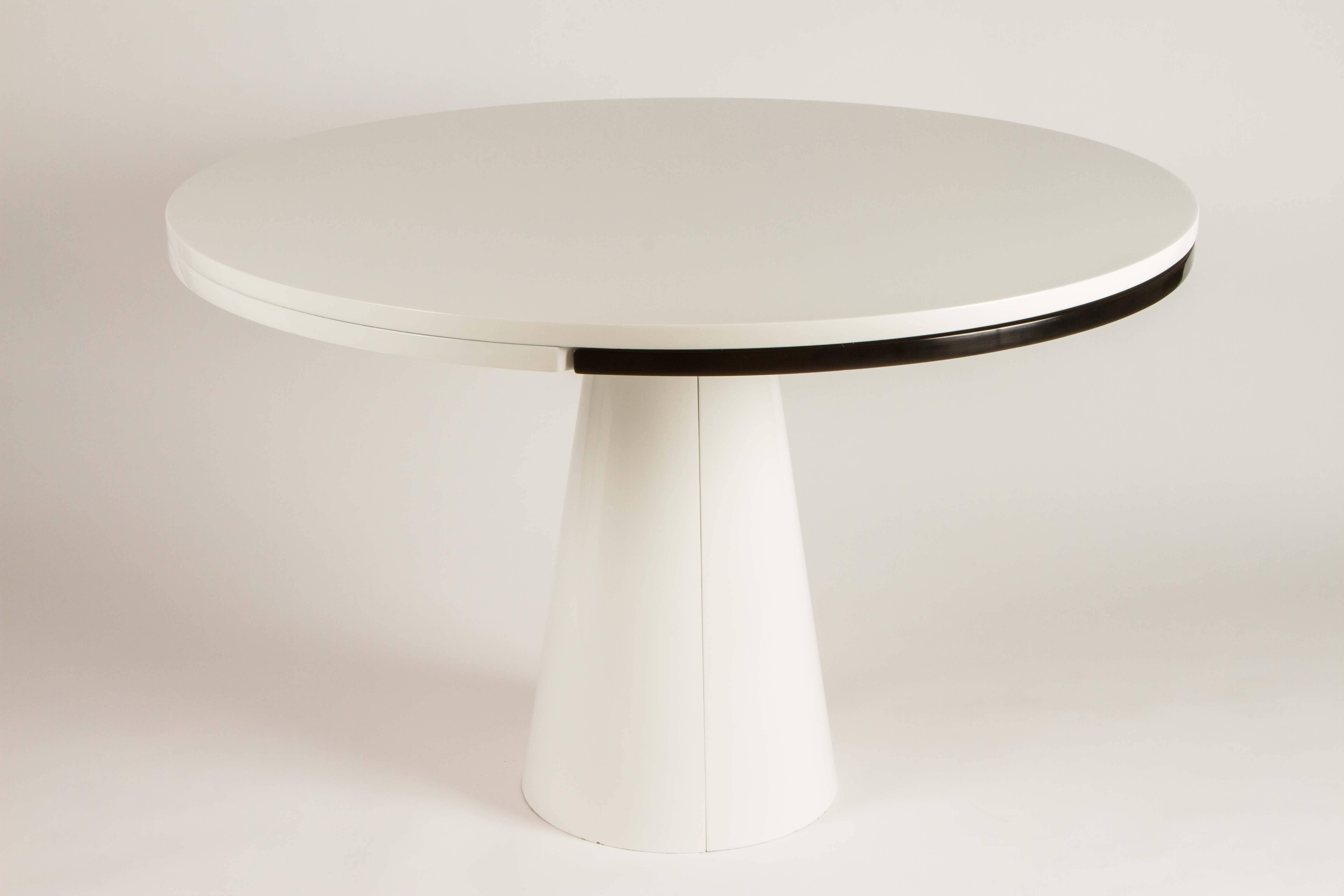 This dining table is very versatile with an unusual method for extending the diameter. The top rotates and drops down slightly and base separates. Closed it is 47