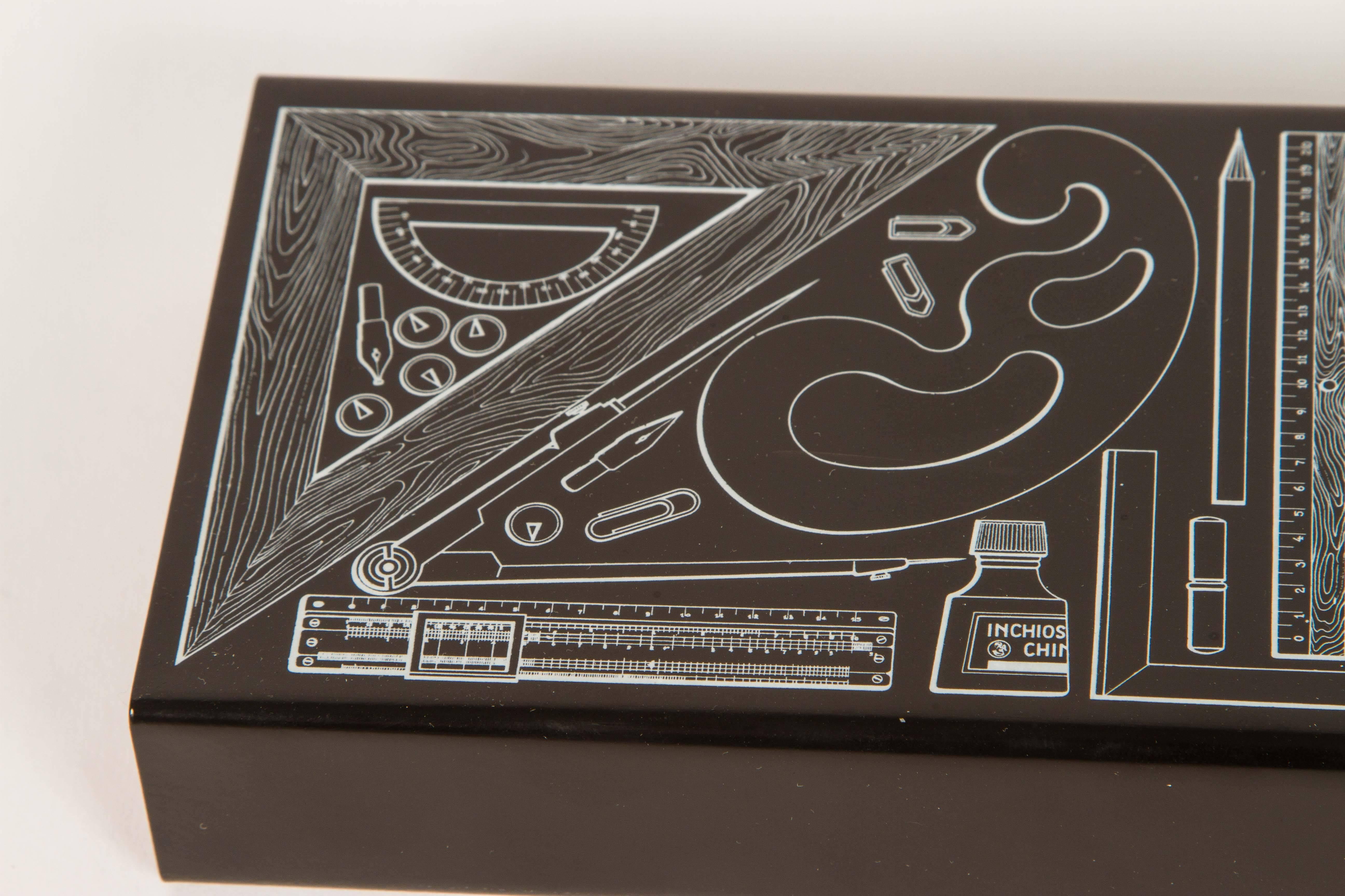 Rectangular box charmingly illustrated with design supplies. Lithography transfer on powder coated metal. With mahogany interior tray and a black felted bottom. Bears Fornasetti Milano marks within the illustration and below. Original packaging