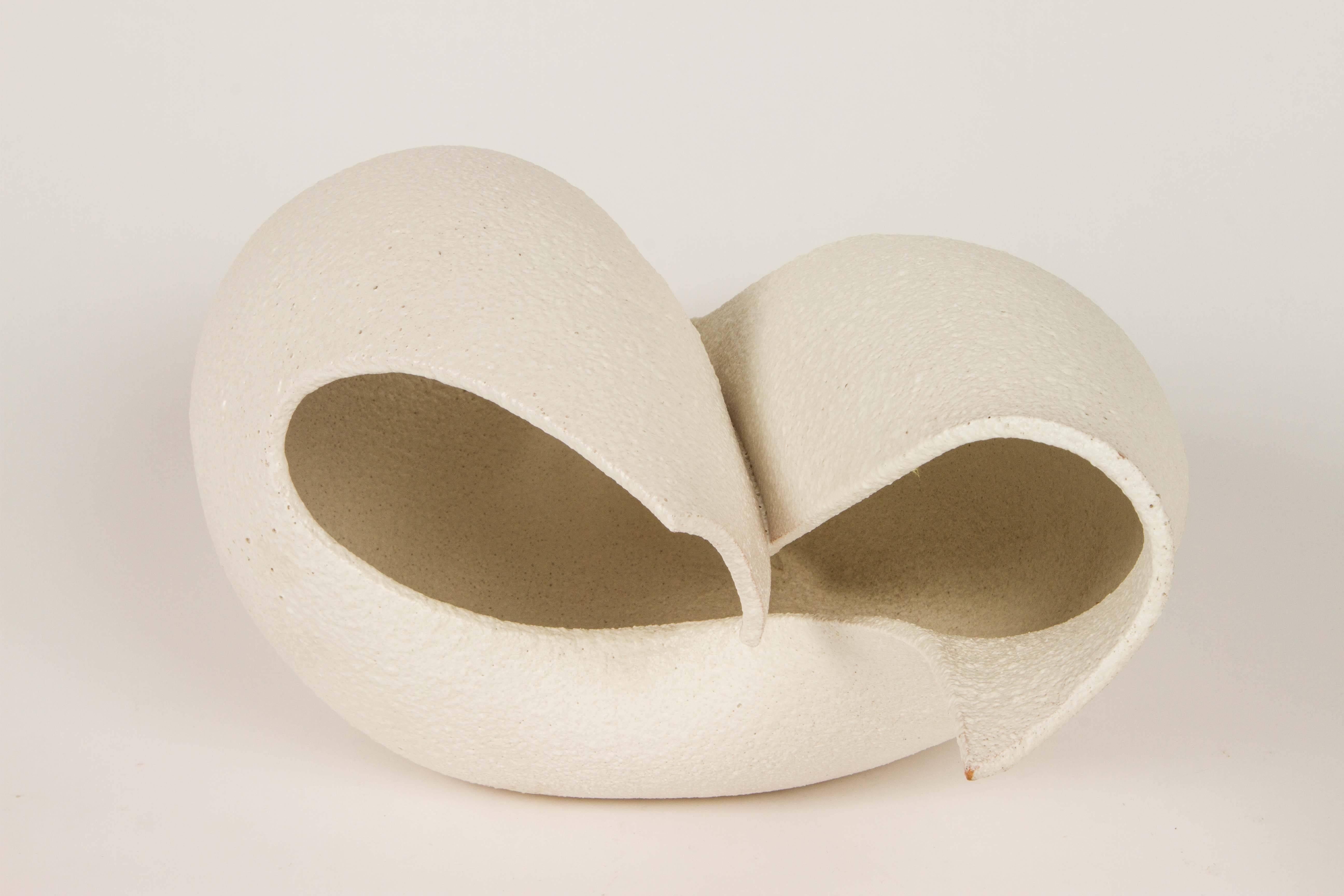 Great abstract sculpture with a white textured glaze. It is signed: 