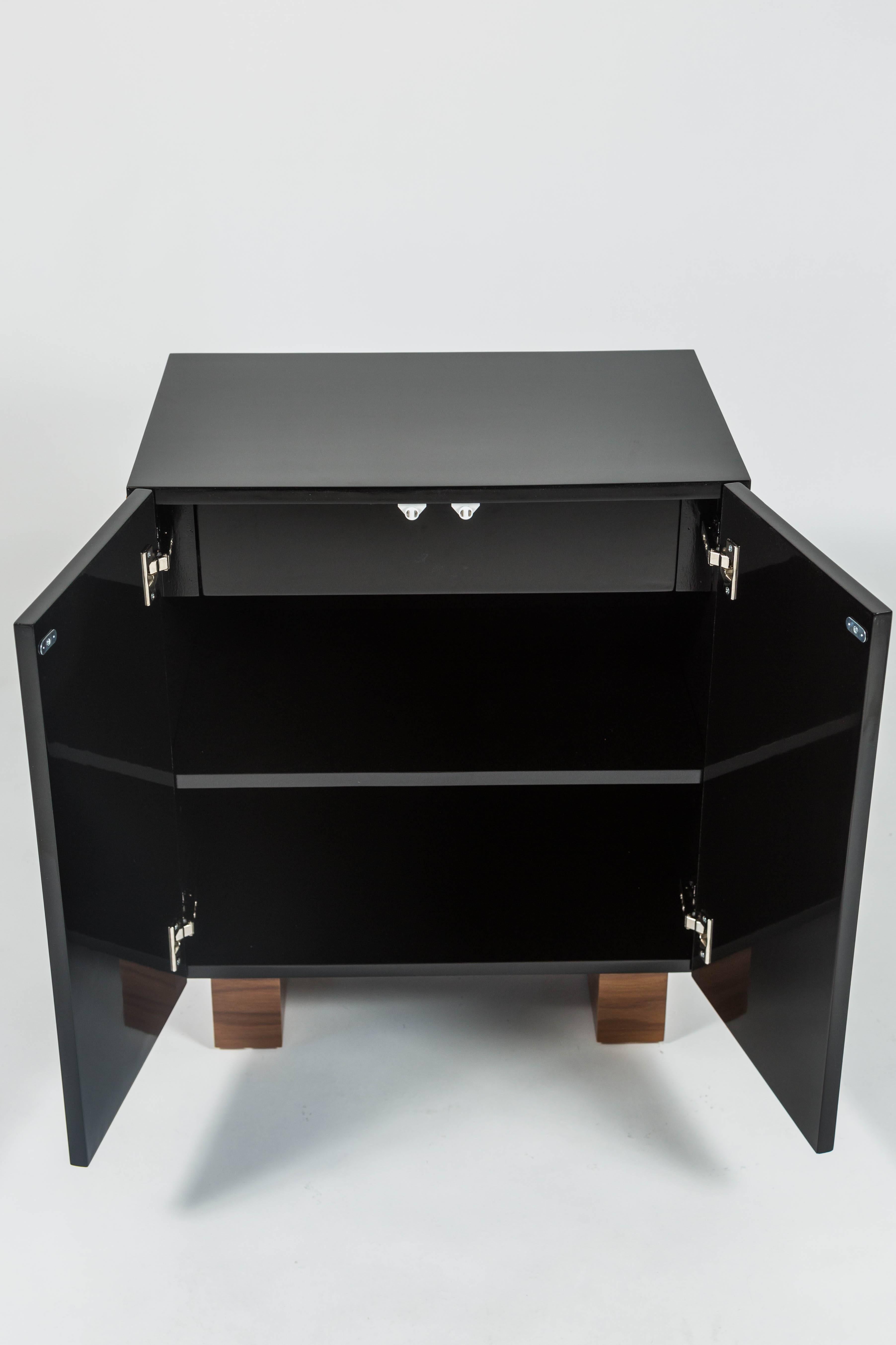 This chic cabinet in black lacquer studded with tigers eye cabochons and with walnut stained feet was designed by Patrick Dragonette for Dragonette Private Label. Featuring touch latch doors the cabinet houses a single drawer inside. This cabinet