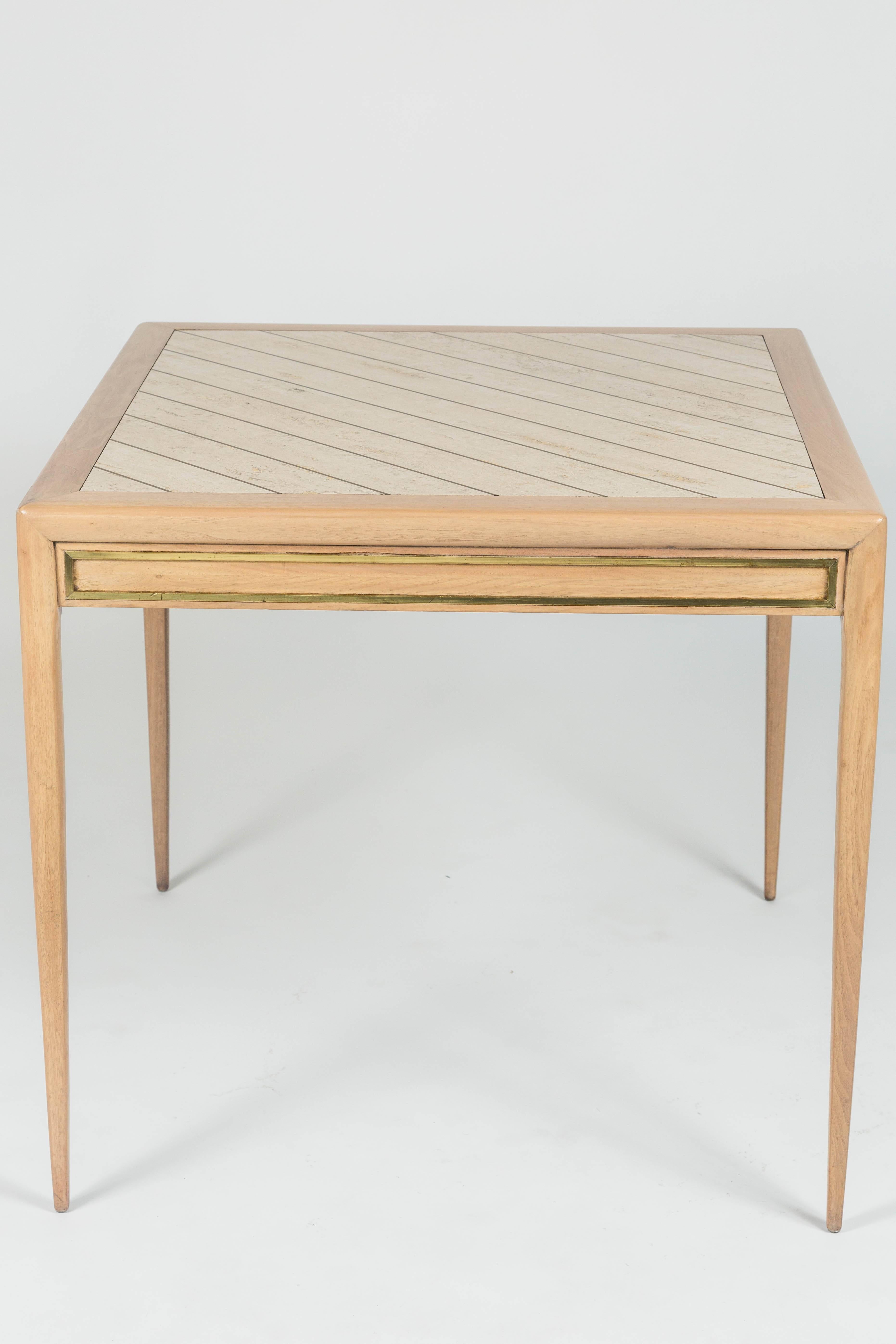 This card table with two pull-out drawers has a formica top mimicking brass inlaid Travertine. Additionally the table has metal trim with a brass finish.
 