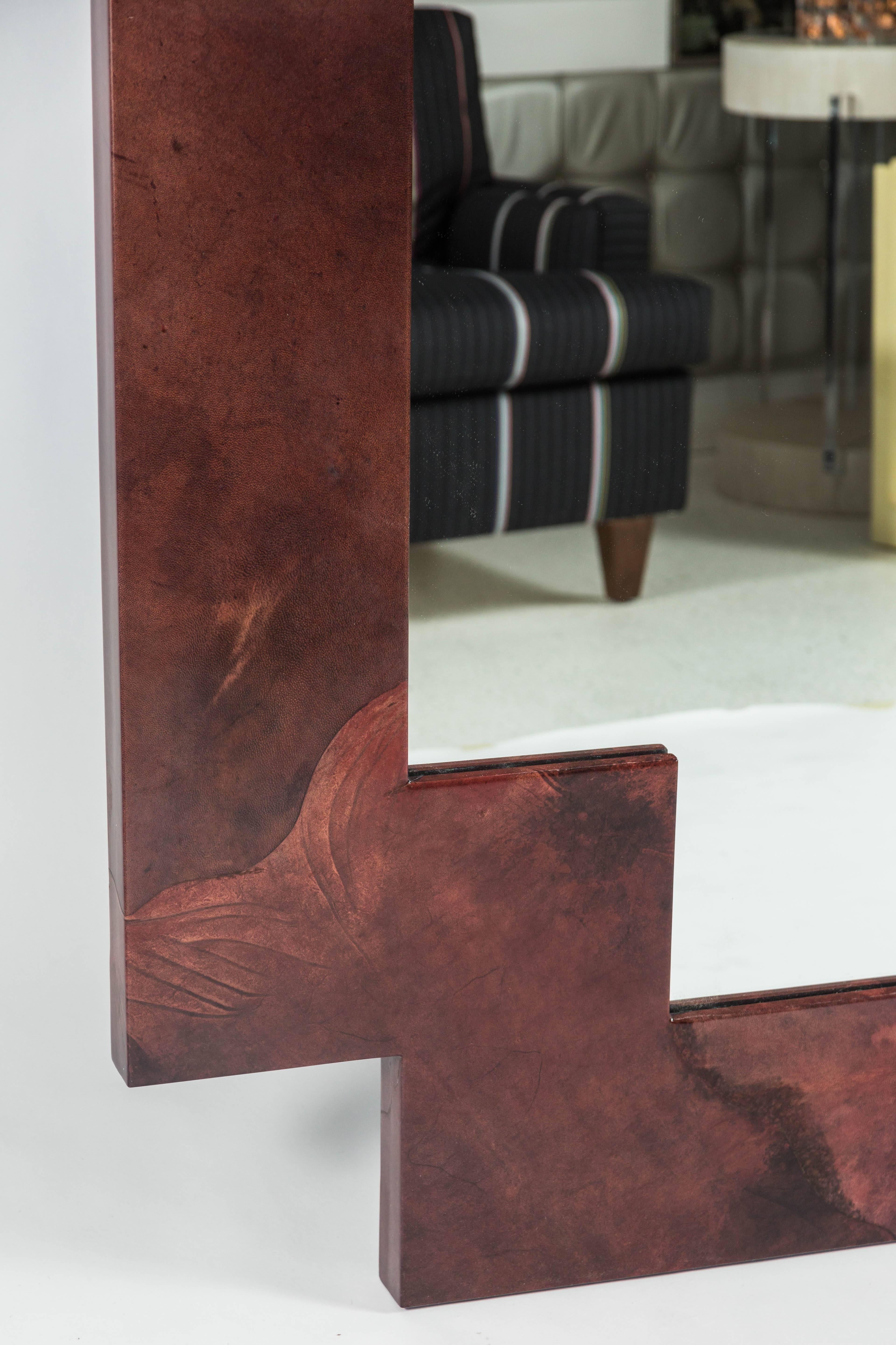 Massive impactful modern mirror by German born American designer Karl Springer. With dark red-brown goatskin veneer and lacquer finish. Stunning. Dated on the reverse: 10-17-87. Can be hung either way.