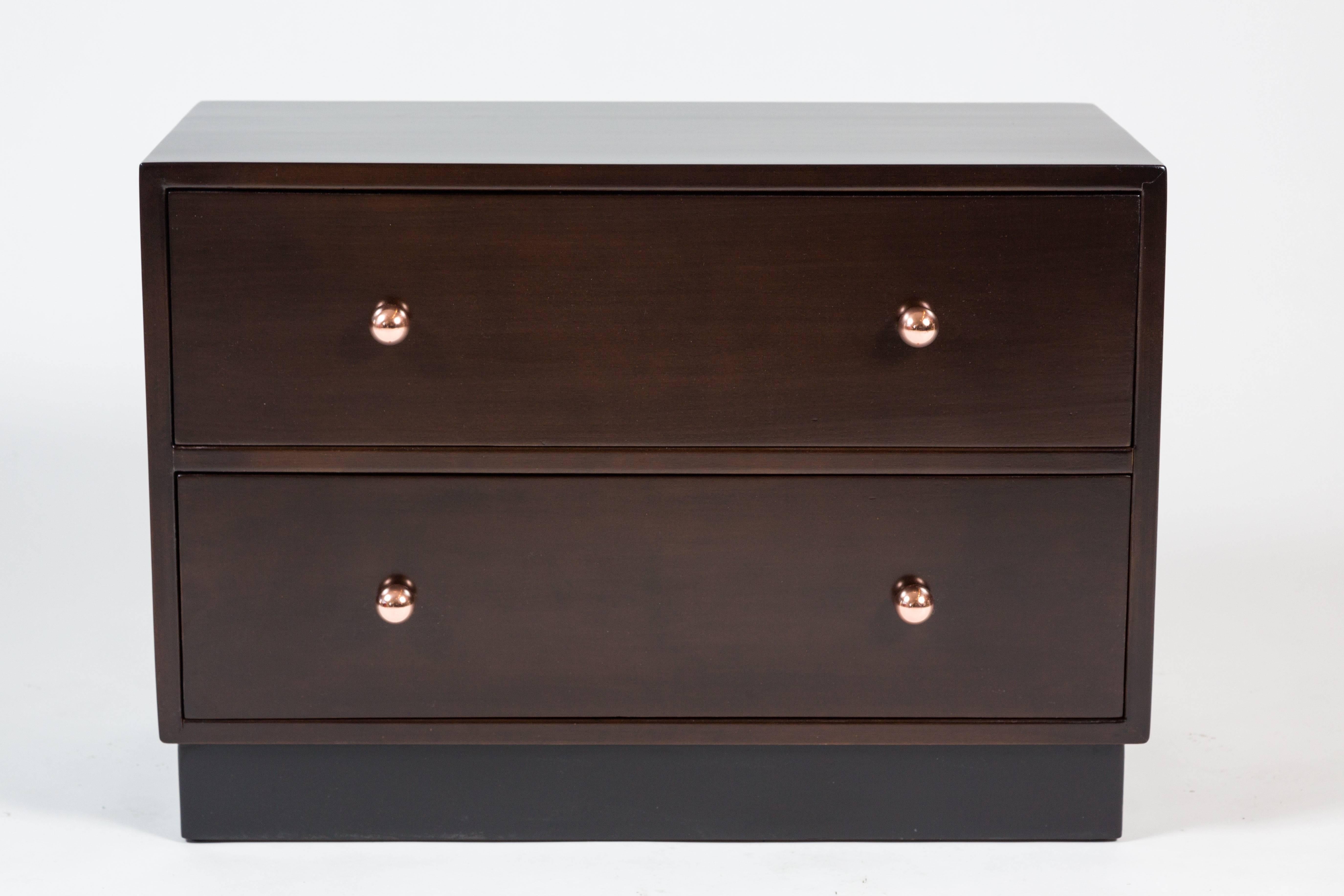 Simple and chic pair of two-drawer bedside chests. In excellent condition; the pair have recently been refinished in a dark espresso hue, and feature polished bronze orb drawer knobs set atop ebonized bases. The original green drawer interiors is in