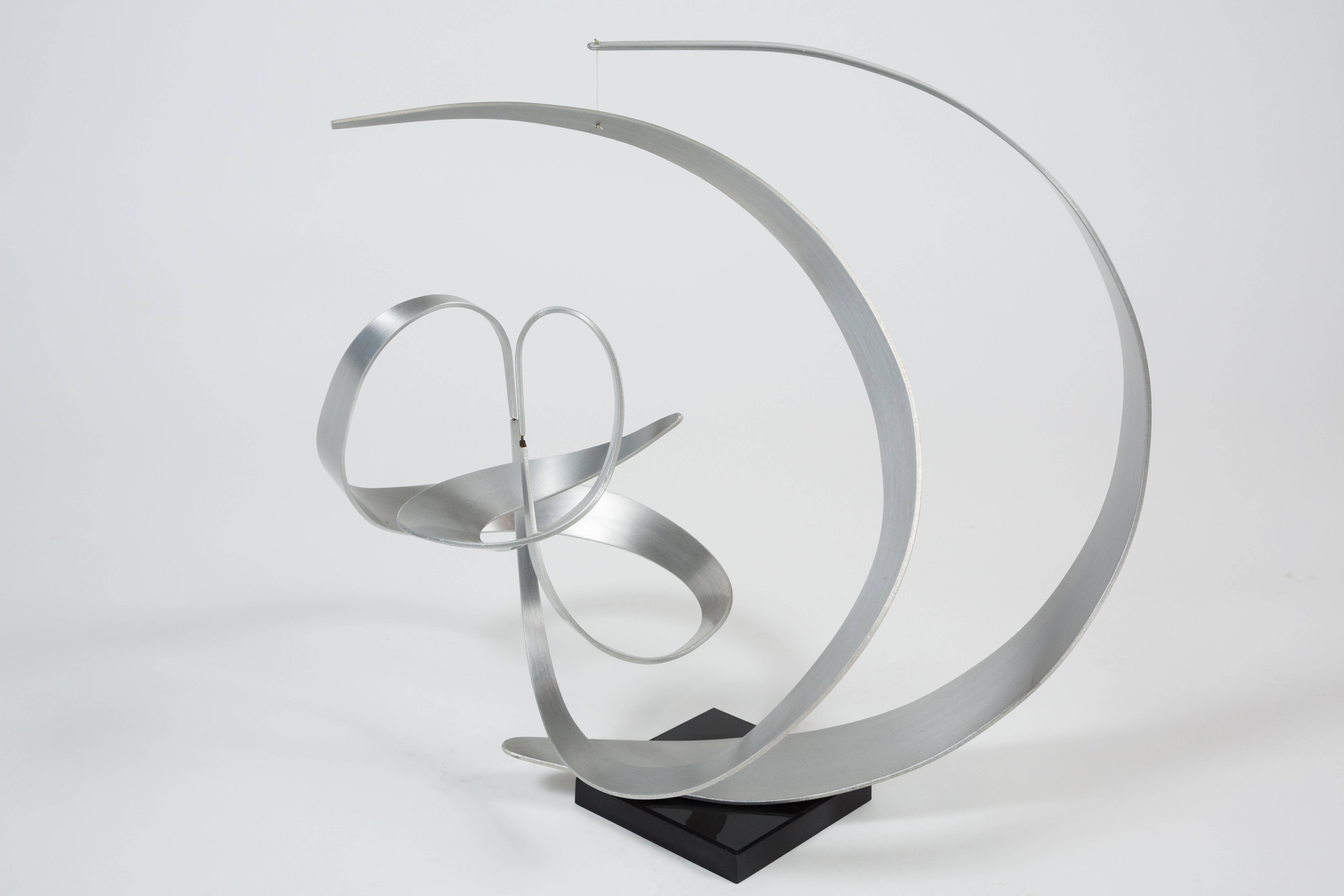 This fabulous Kinetic abstract sculpture by John W. Anderson, features three distinct free-moving pieces. Bearings attach the three metal segments which move at the slightest touch, making for a work of art that is perpetually changing and new. The