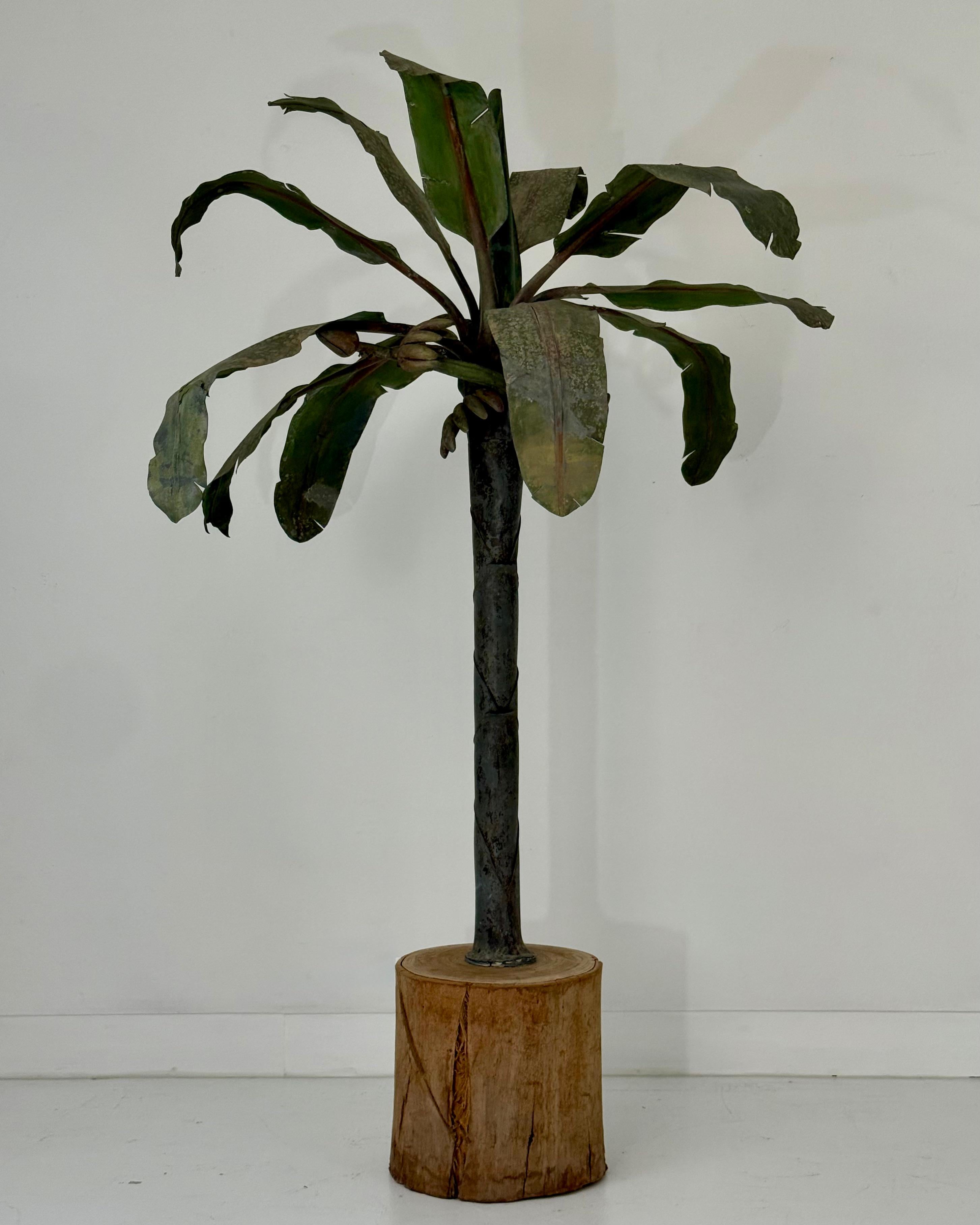 An evocative and rare decorative object, this 1920s tôle palm tree sculpture brings an exotic and whimsical flair to any interior. The piece features finely hand-cut and painted metal fronds that arc with a natural, timeworn patina, reflecting its