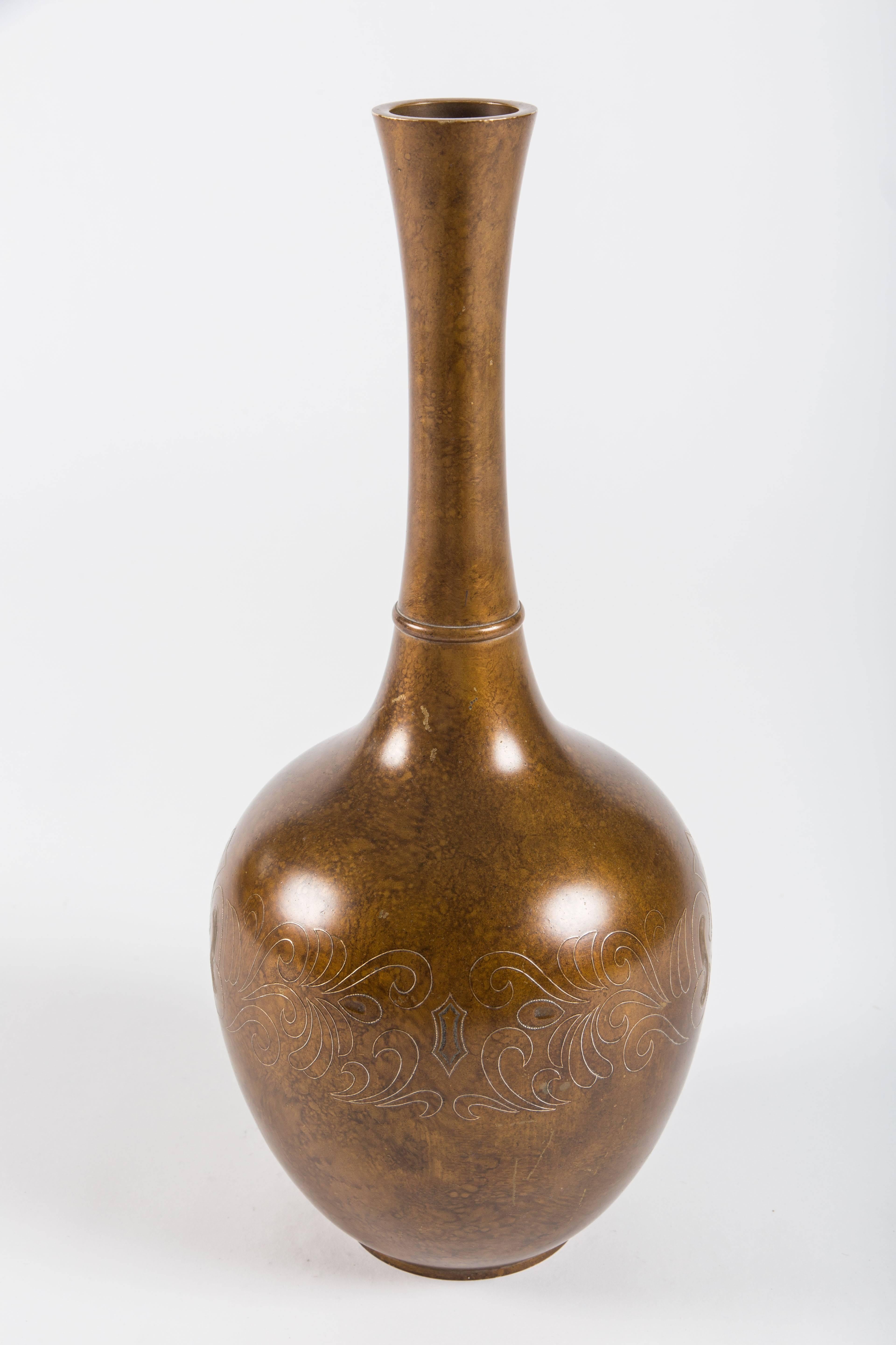 Beautiful long narrow necked vase with decorations reminiscent of Syrian artistic traditions. Features lovely decorative applied metal relief, and engraving. Vase is brass and has a lovely patina.

Measures: 19 1/2 inches high.

