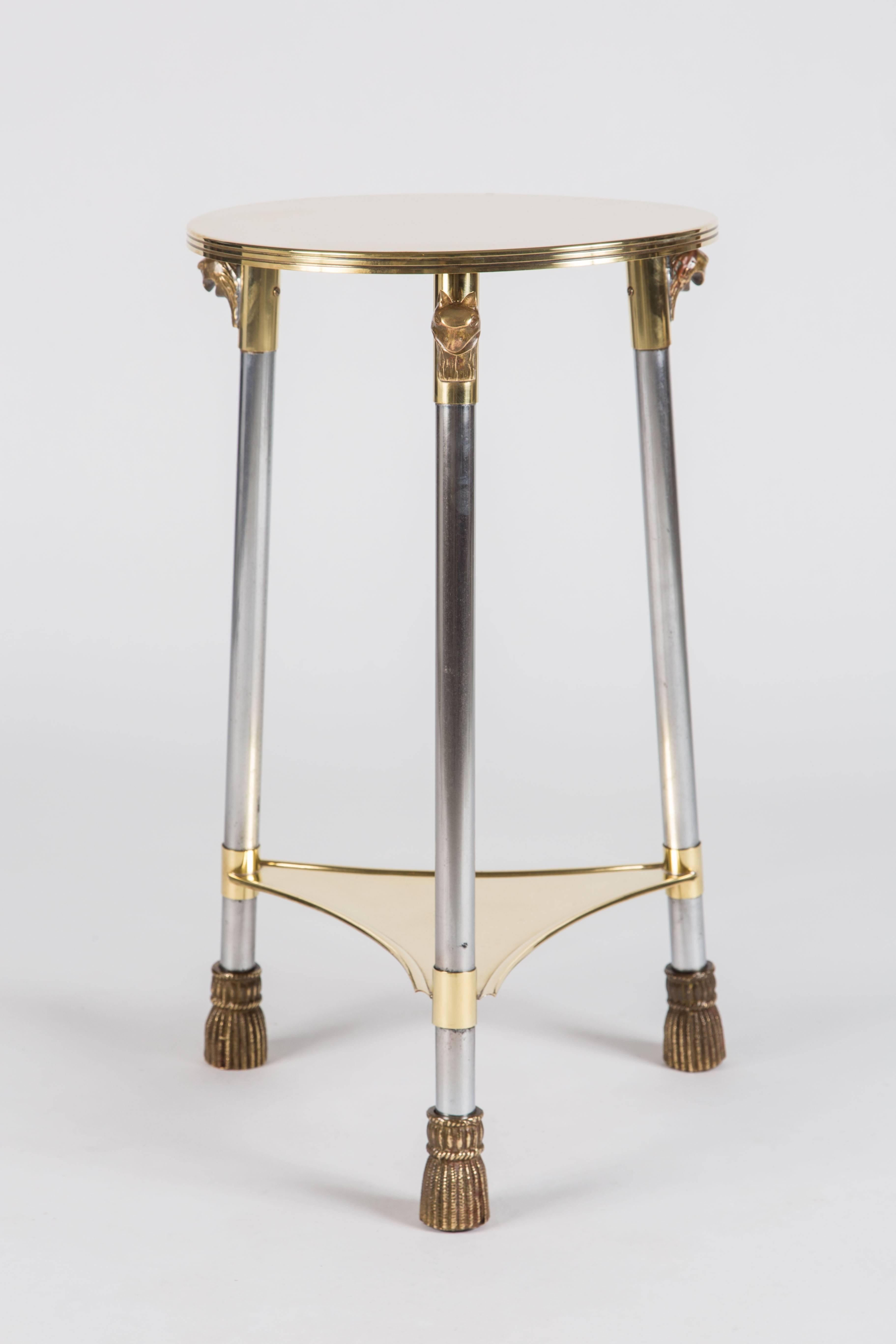 Fantastic tiered stand in polished brass and steel, featuring decorative cat heads about the legs. The legs terminate in tassel motif decorated feet.

Measures: 24 1/4 inches high.