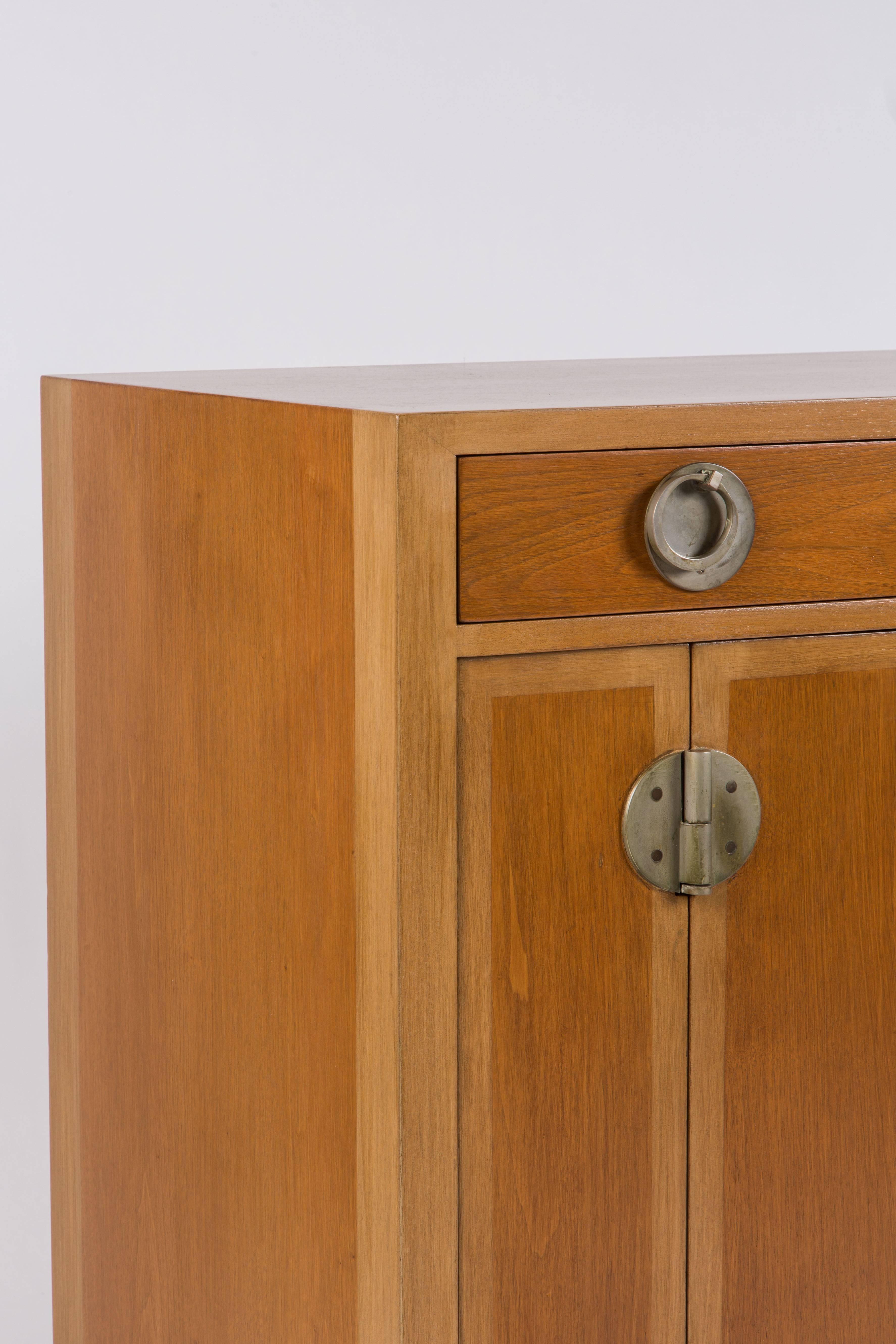 Timeless cabinet with Chinese design accents, by renown American Mid-Century designer Edward Wormley for Dunbar. With two tone bleached Mahogany veneers and brass hardware recalling the hardware used on traditional Chinese furniture. With green