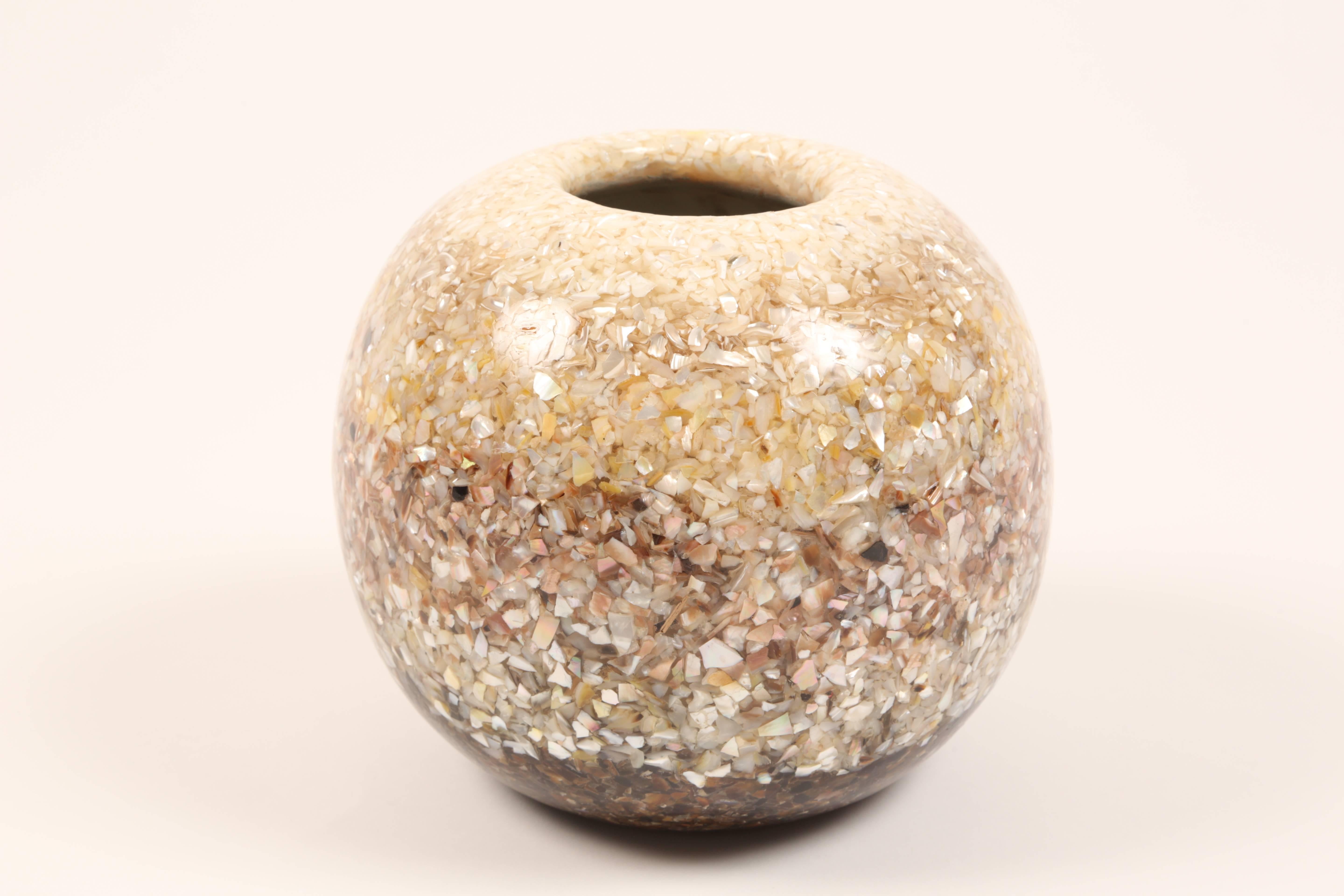 Striking vase composed of mother-of-pearl and sea shell fragments in resin composite. The fragments are arranged in a gradient which flows from white and gold hues at the top, to rose hues at the middle and on to dark purple and brown hues at the