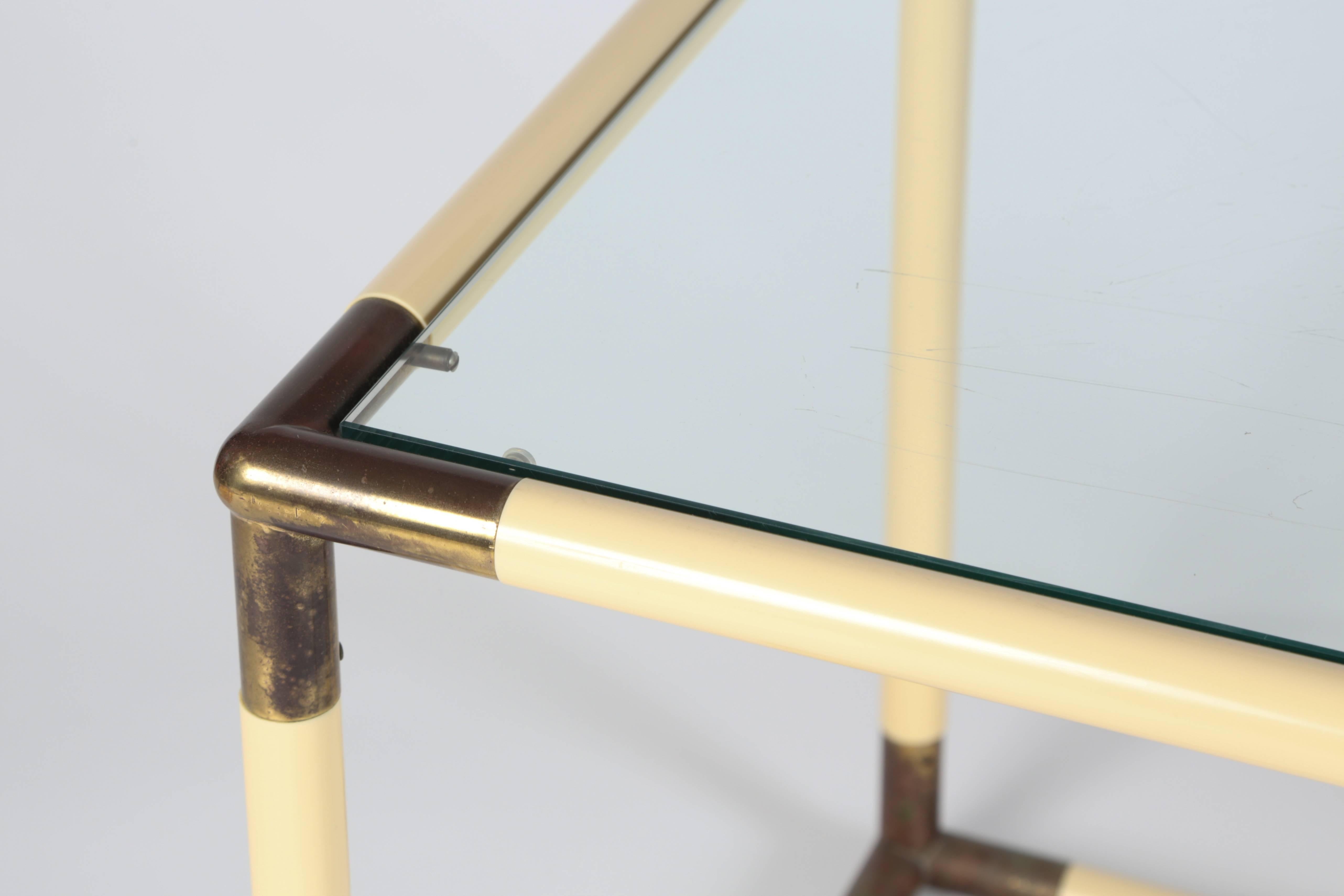 Fantastic cube form glass top table. Brass corner pieces connect 1 inch thick tubular segments simulating parchment. The brass has developed a wonderful patina.

We believe the table to be Italian in origin.

We are also selling the same table