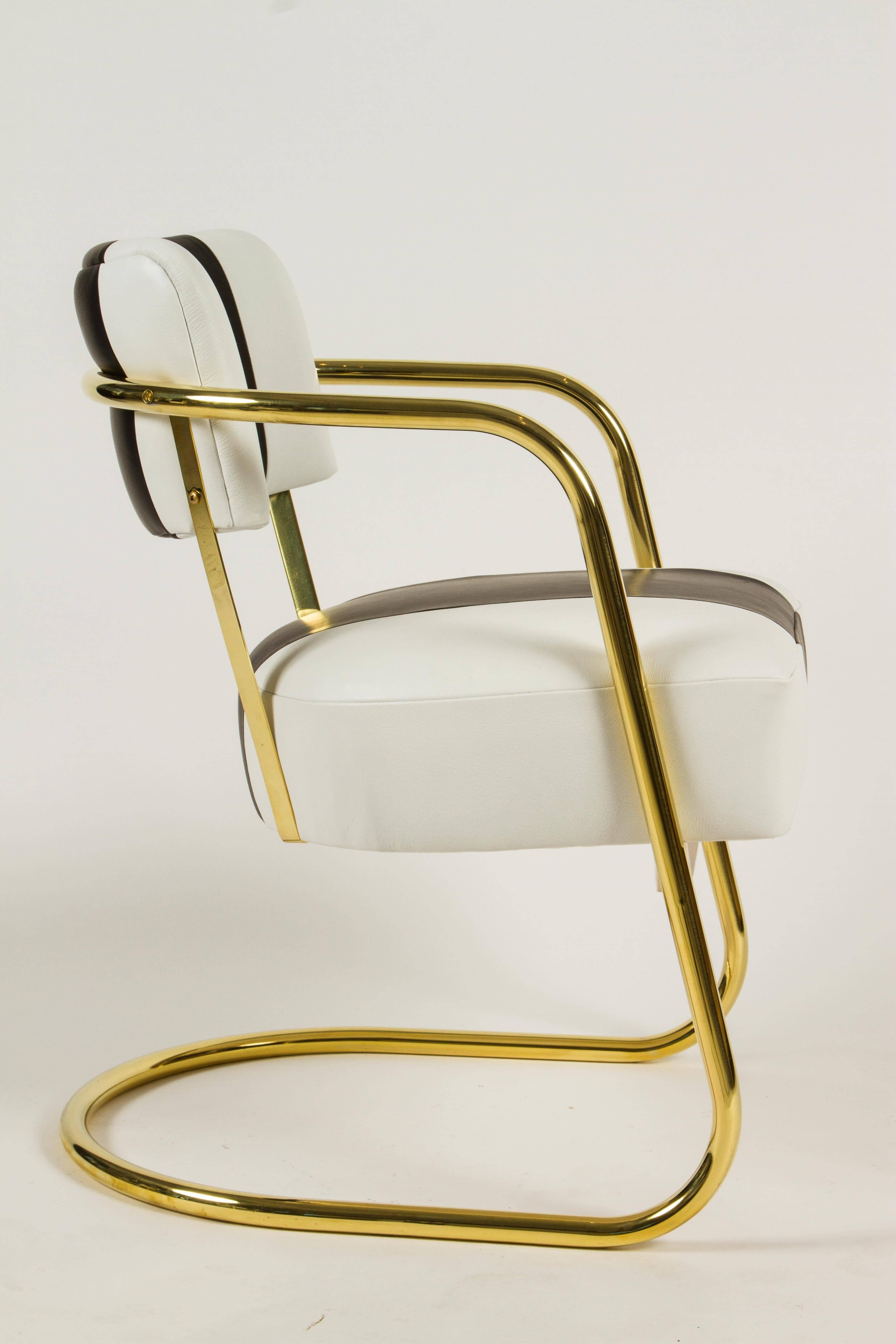 A great group of six period Art Deco chairs attributed to Gilbert Rhode.
The chairs have been plated in brass for a more contemporary feel and have been reupholstered in white leather with a contrasting black leather stripe down the center of the