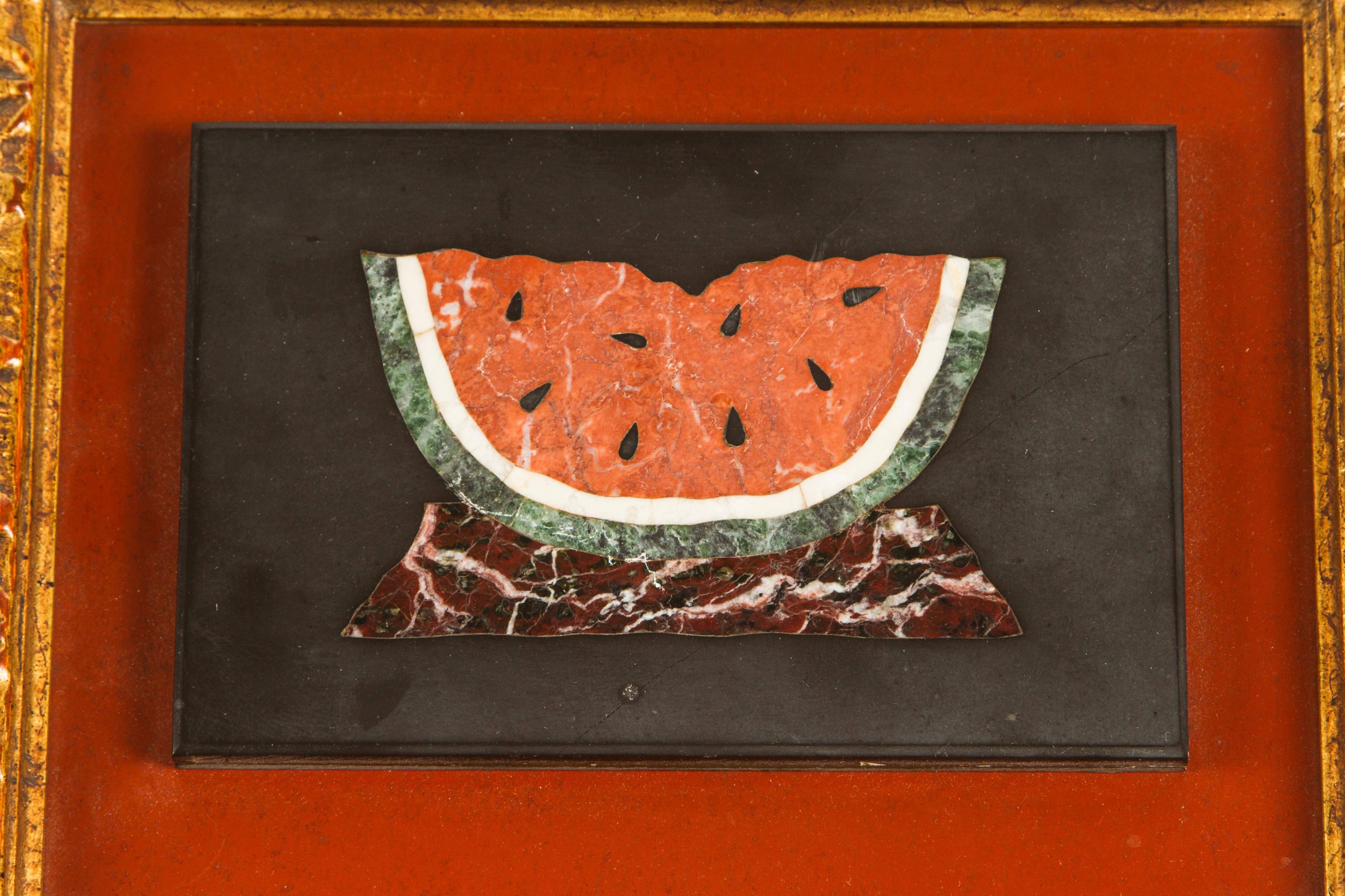 A unique "painting" created entirely of various stones. This charming piece depicts a slice of watermelon. Made using slate for the background the watermelon is comprised of red, white and green marble and rest on a burgundy table. In its