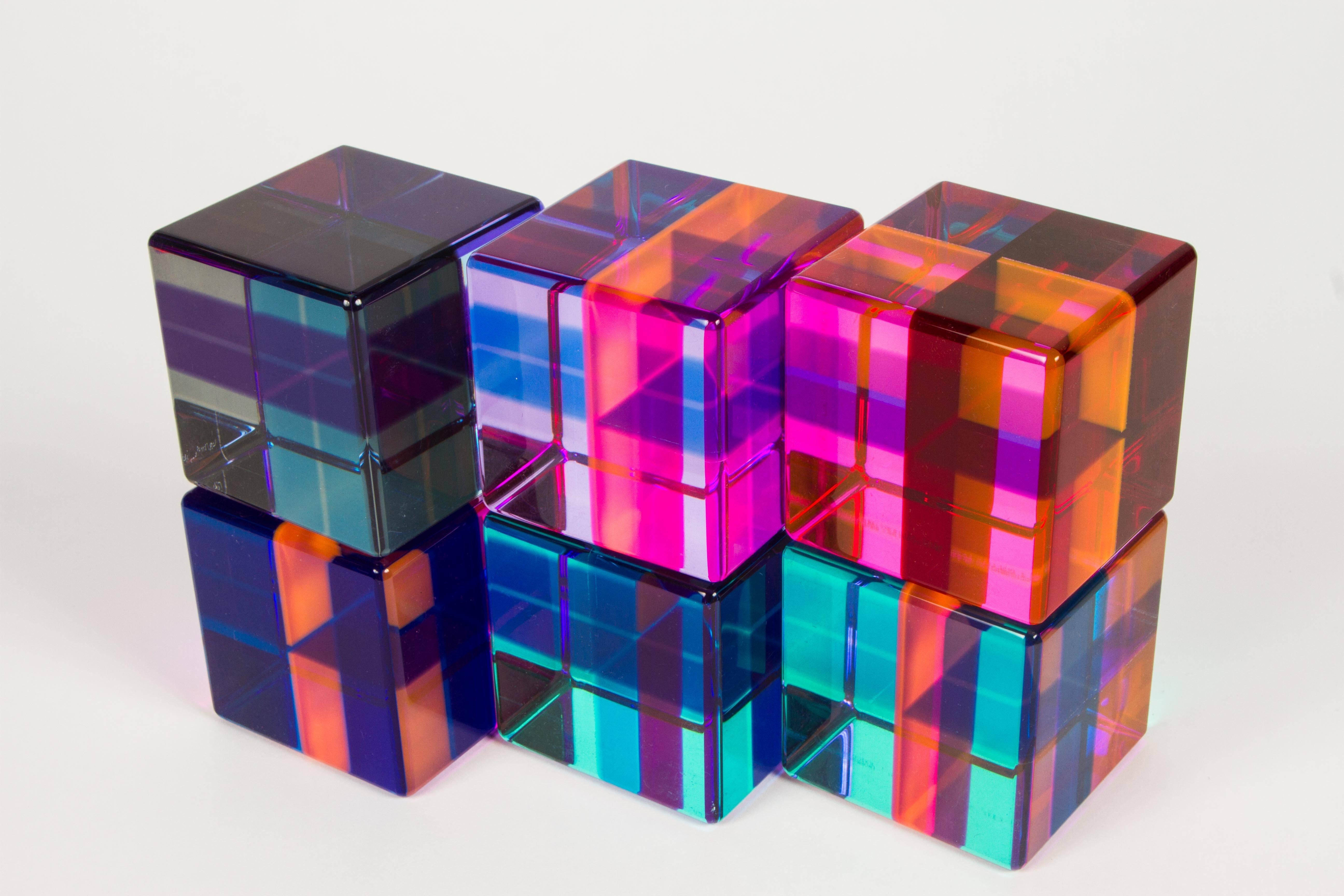 A group of six large plexiglass cubes that can be configured in any number of ways. Each cube is cut by several colors and depending on the placement the colors change. One of the six cubes is signed (see images 9/10). Dated 1999.