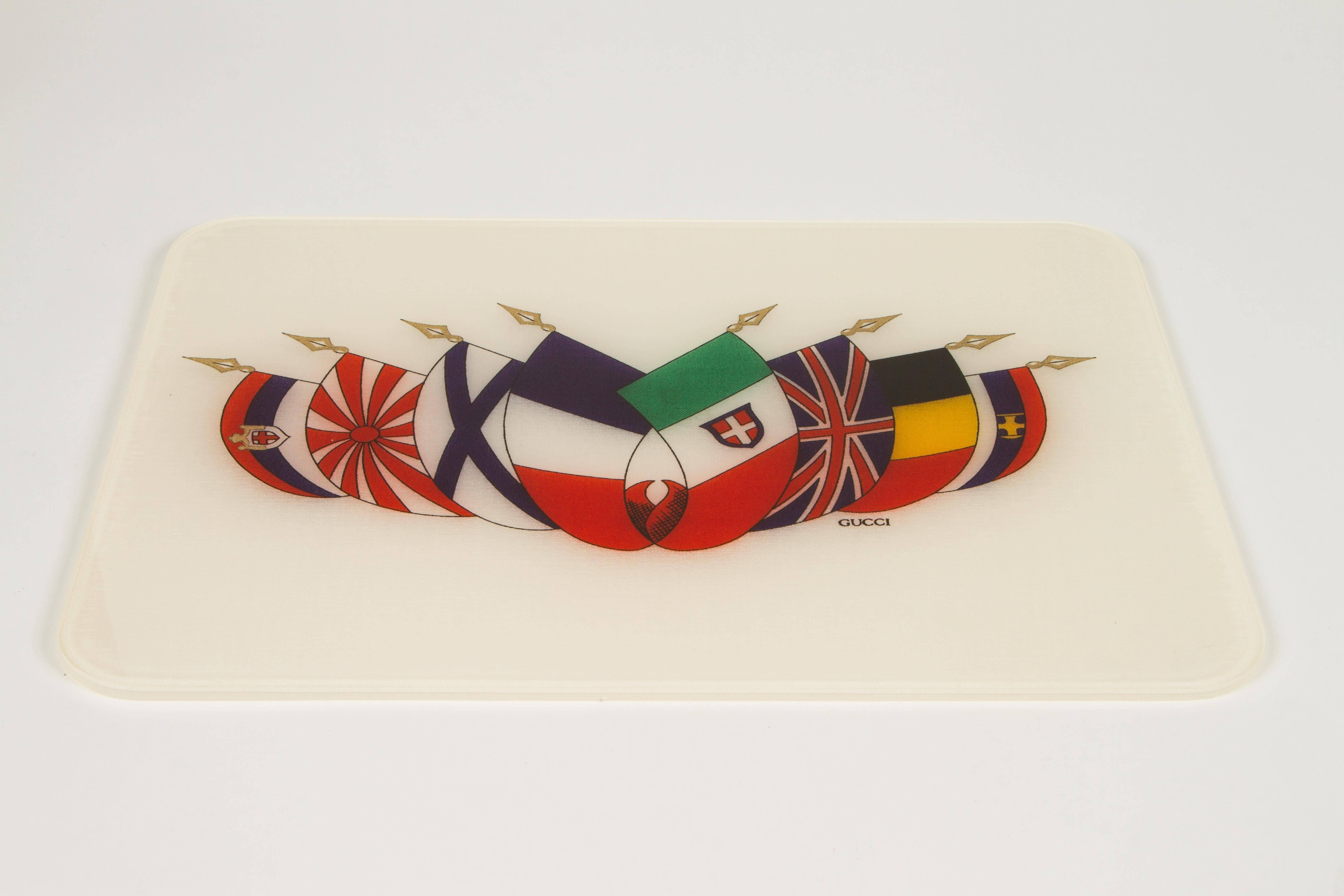 This is an awesome find! A group of 12 vintage Gucci placemats dating to the 1970s. These mats have a linen core printed with flags of various nations which are very colorful and striking. On the reverse the Gucci seal along with 