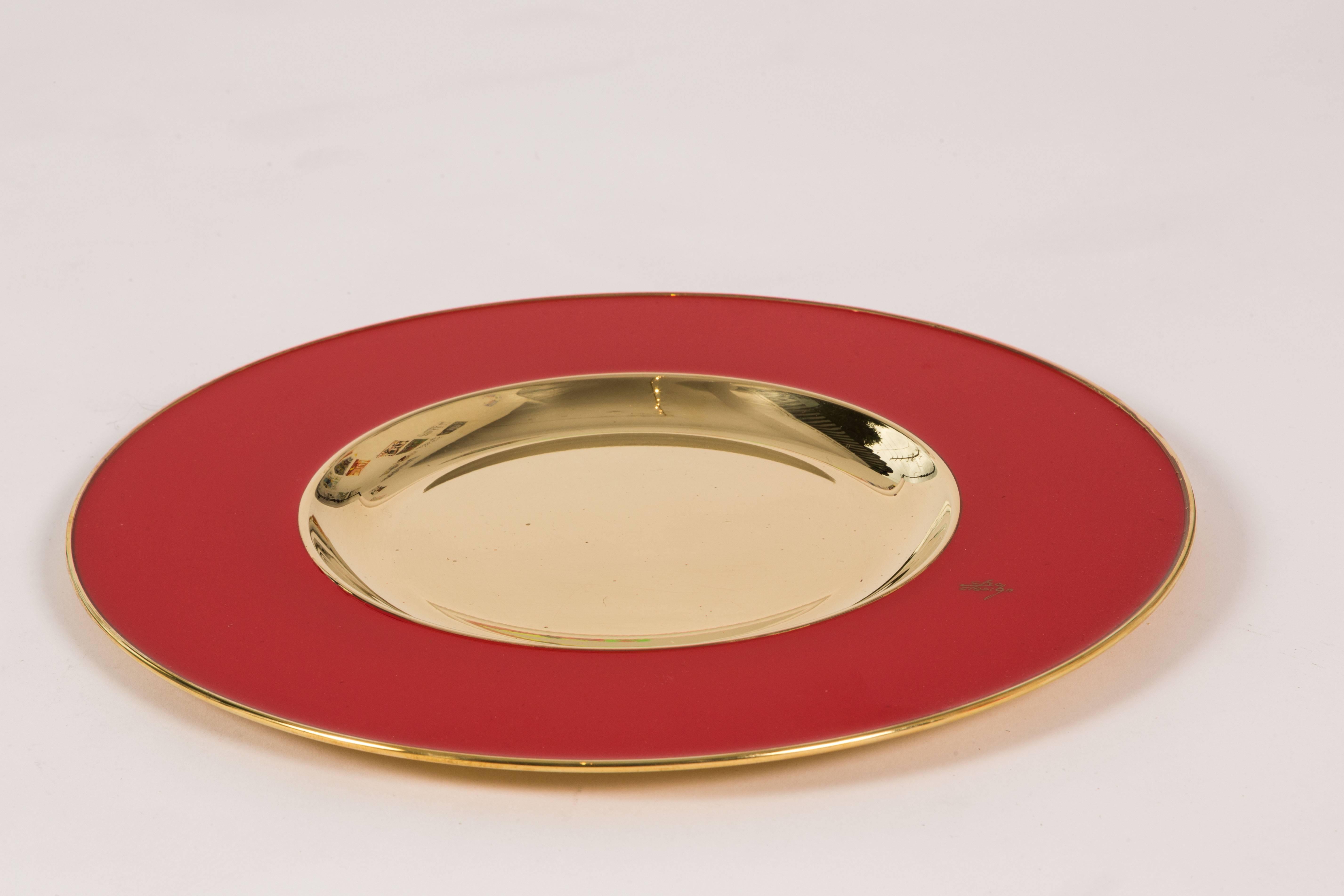 A fabulous group of six table chargers in brilliant red and brass. The chargers are signed on the face with Etro Design; and I am not sure if this is the same Etro that makes clothing. They are quite striking. There are a total of seven chargers,