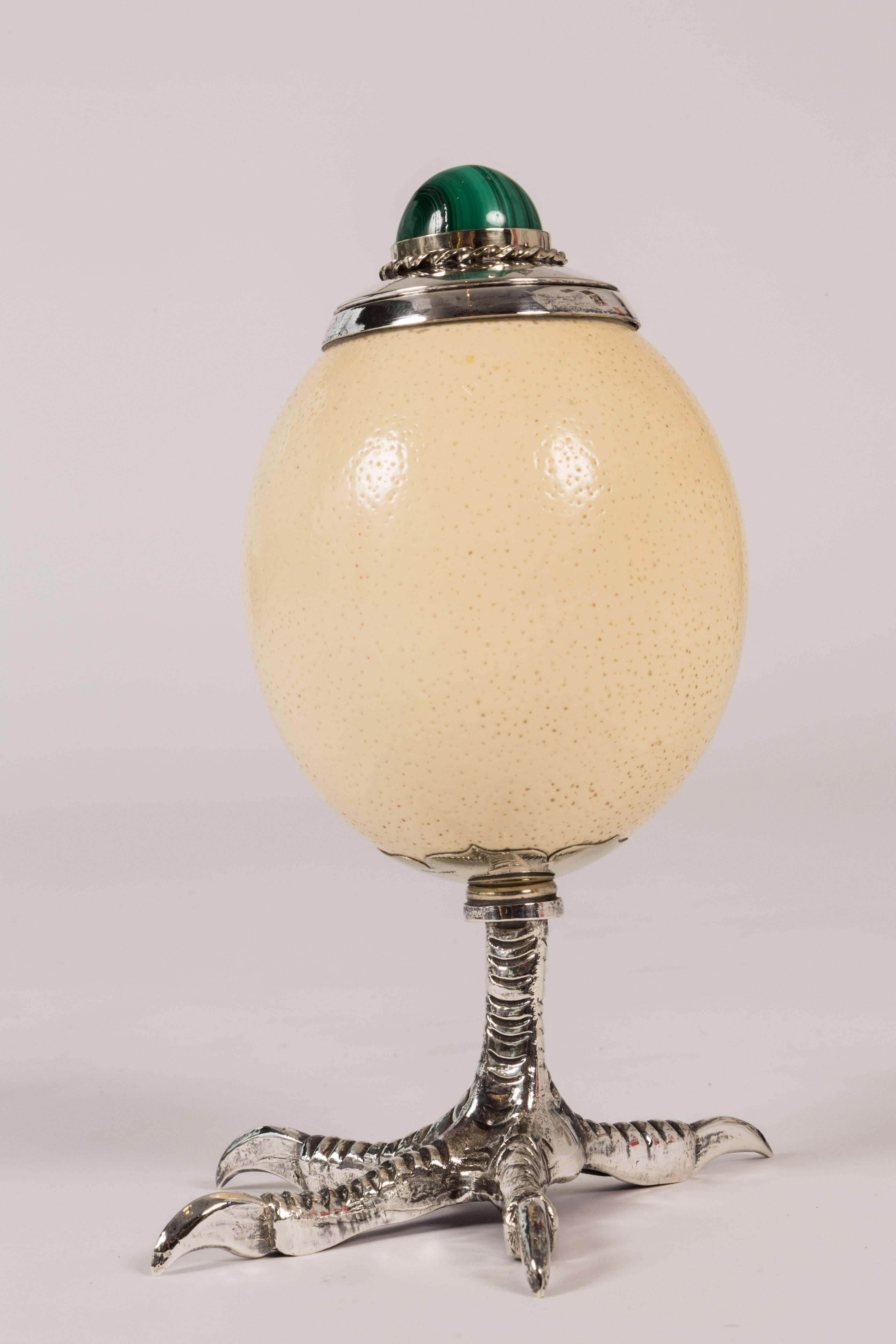 Here is a chance to own a unique Antony Redmile box, originally intended for cigarettes. Here as in many of his designs he uses an ostrich egg, after hollowing out adding a silver plated liner and lid topped off by a large malachite stone finial.