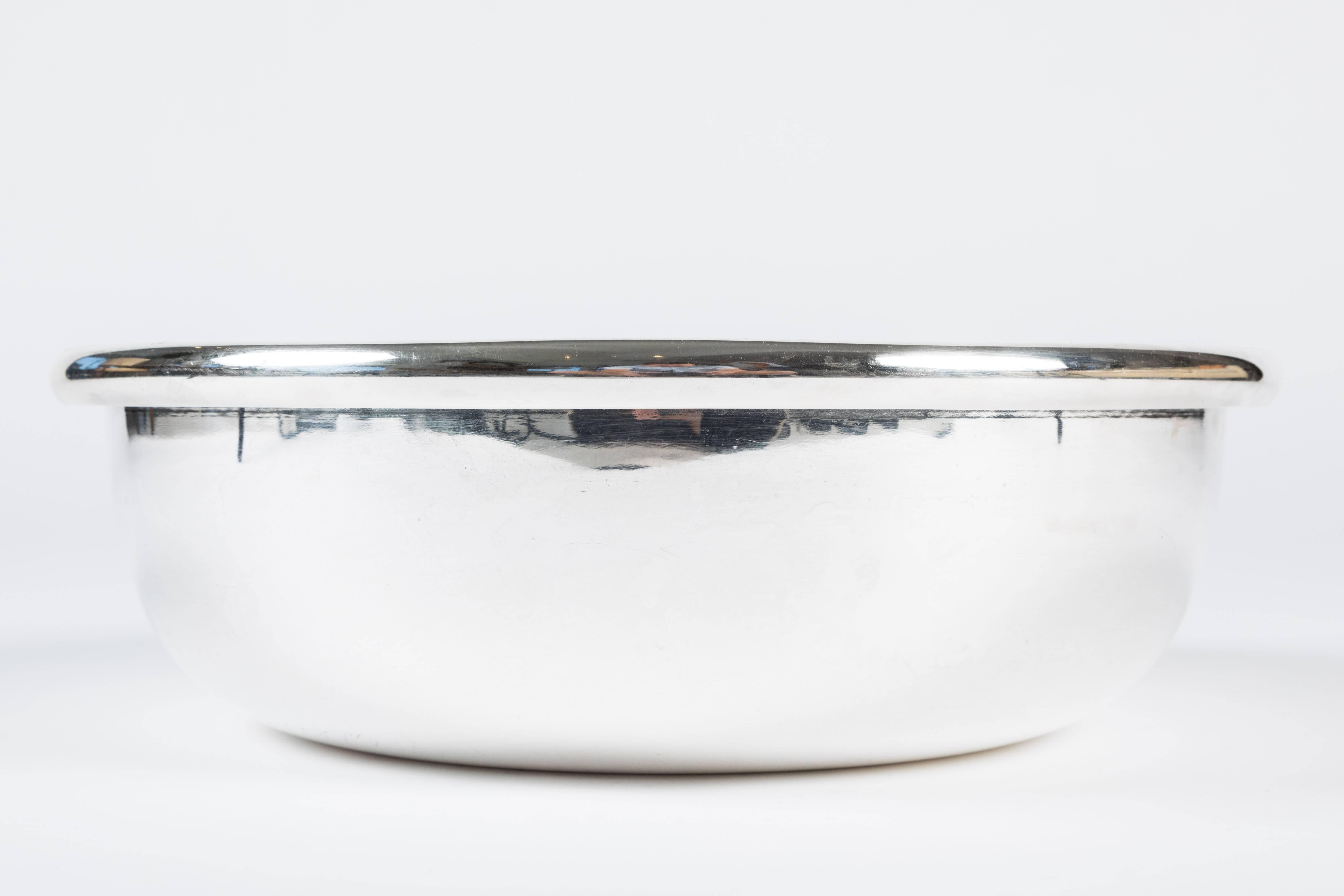 Sleek and substantial silver plated serving bowl by Sabattini. The bowl has a 5/8 of an inch rim and the bottom is stamped Sabattini / Made in Italy with maker's mark.