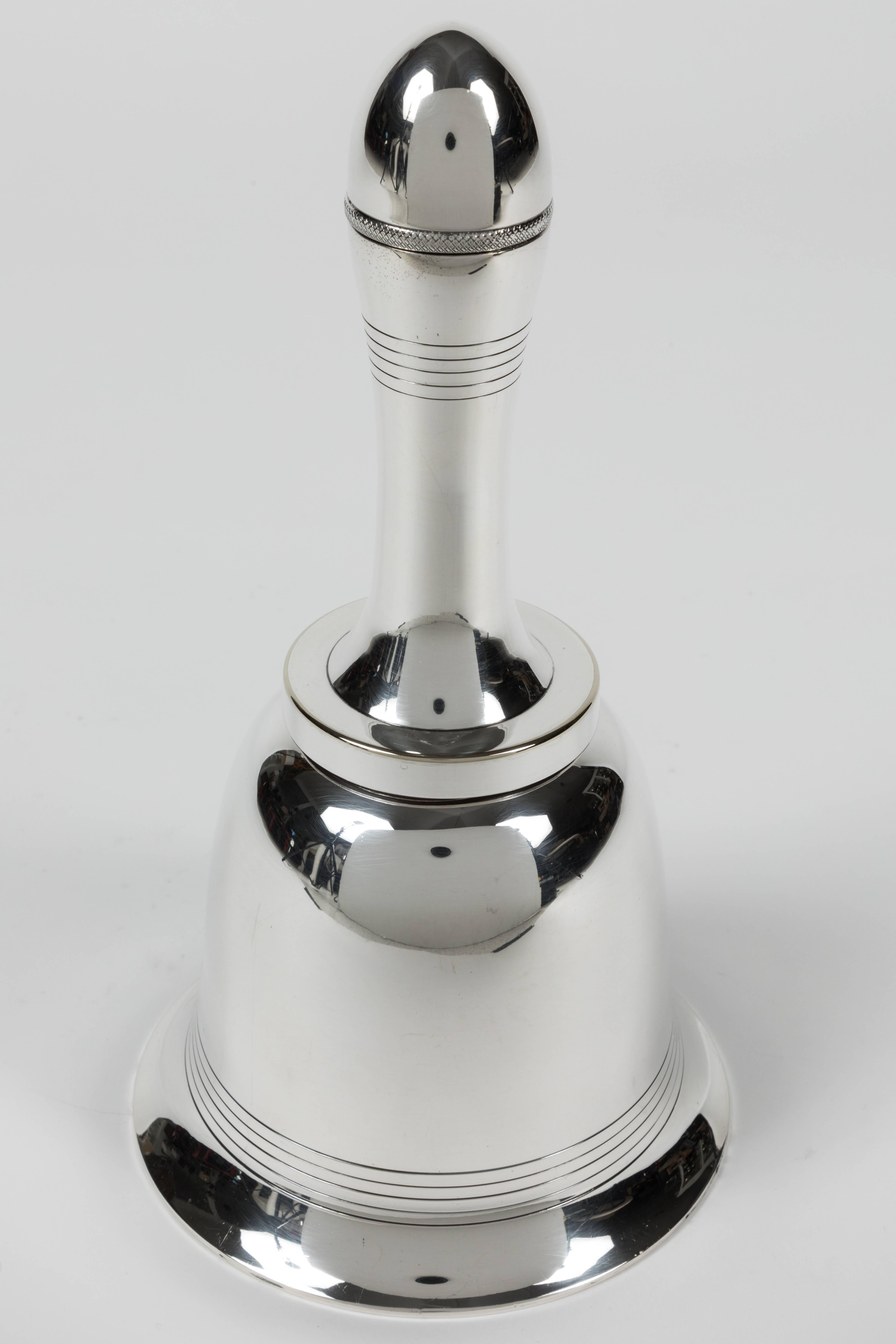 This is a real collector item, this cocktail shaker in the form of a hand bell was designed and made by Asprey & Co in 1935. Bell breaks down into three sections for use. The top unscrews to pour the drinks. Silver plate is in fine condition. Fully