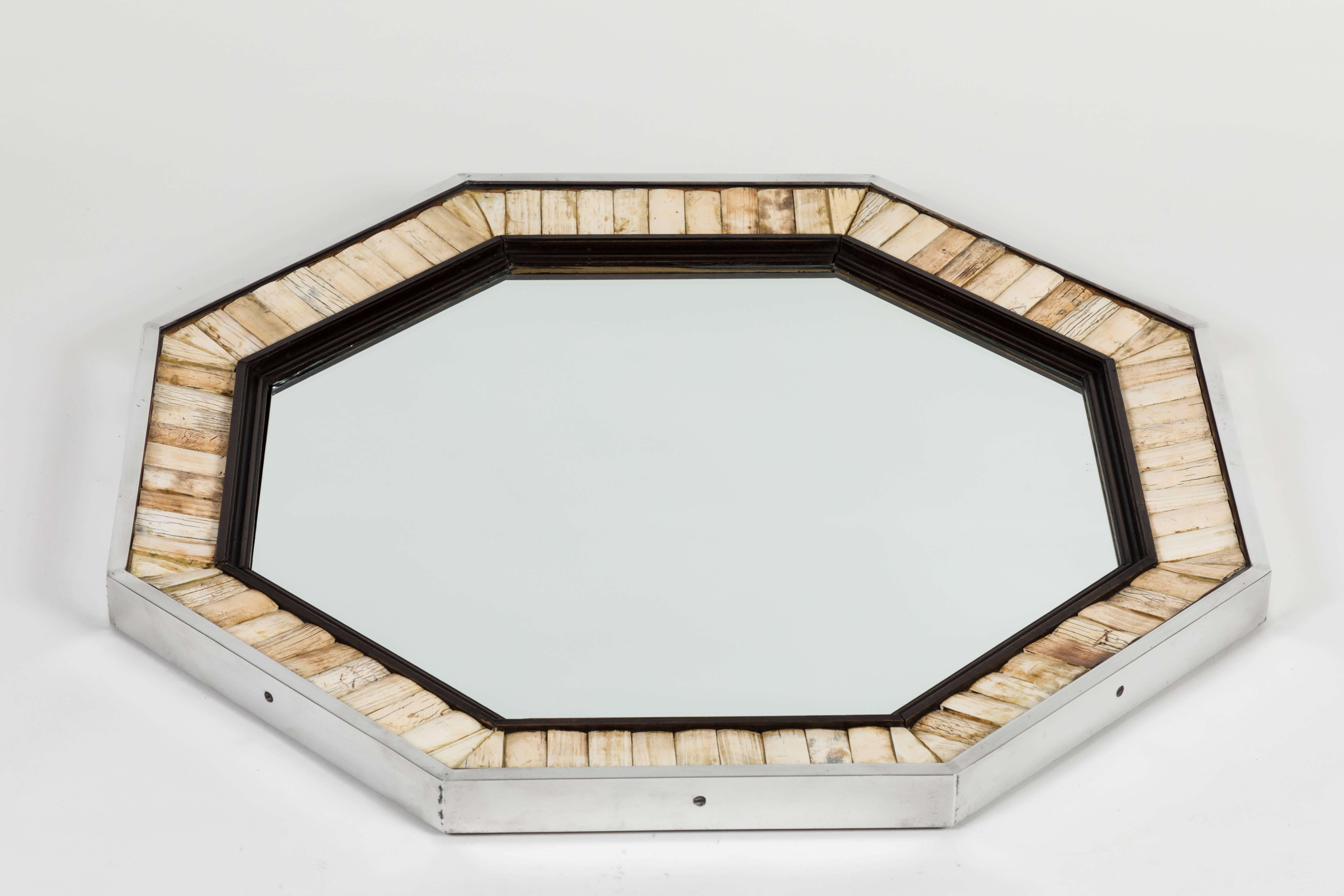 Wonderful and stylish mirror framed in ebonized wood surrounded by bone inlays and finished with a polished aluminum surround. Though unsigned, the work of 1970s London designer Antony Redmile, this mirror is a variation of several signed versions I