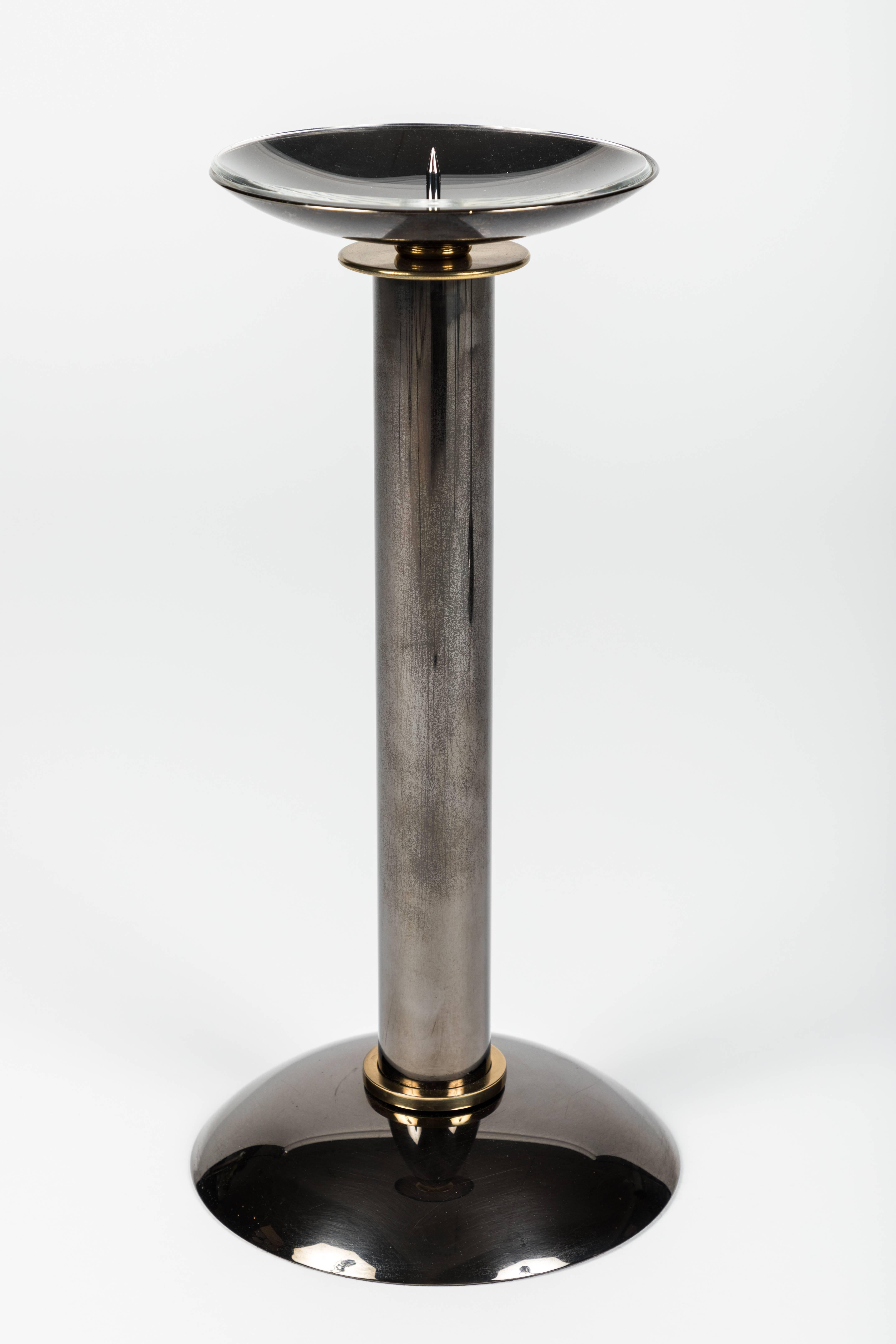 These signature Karl Springer candlesticks are composed of gunmetal bodies with brass accents. The original Lucite liners are included.

Karl Springer (born in Berlin) was a designer and manufacturer of luxury furniture and a wide array of