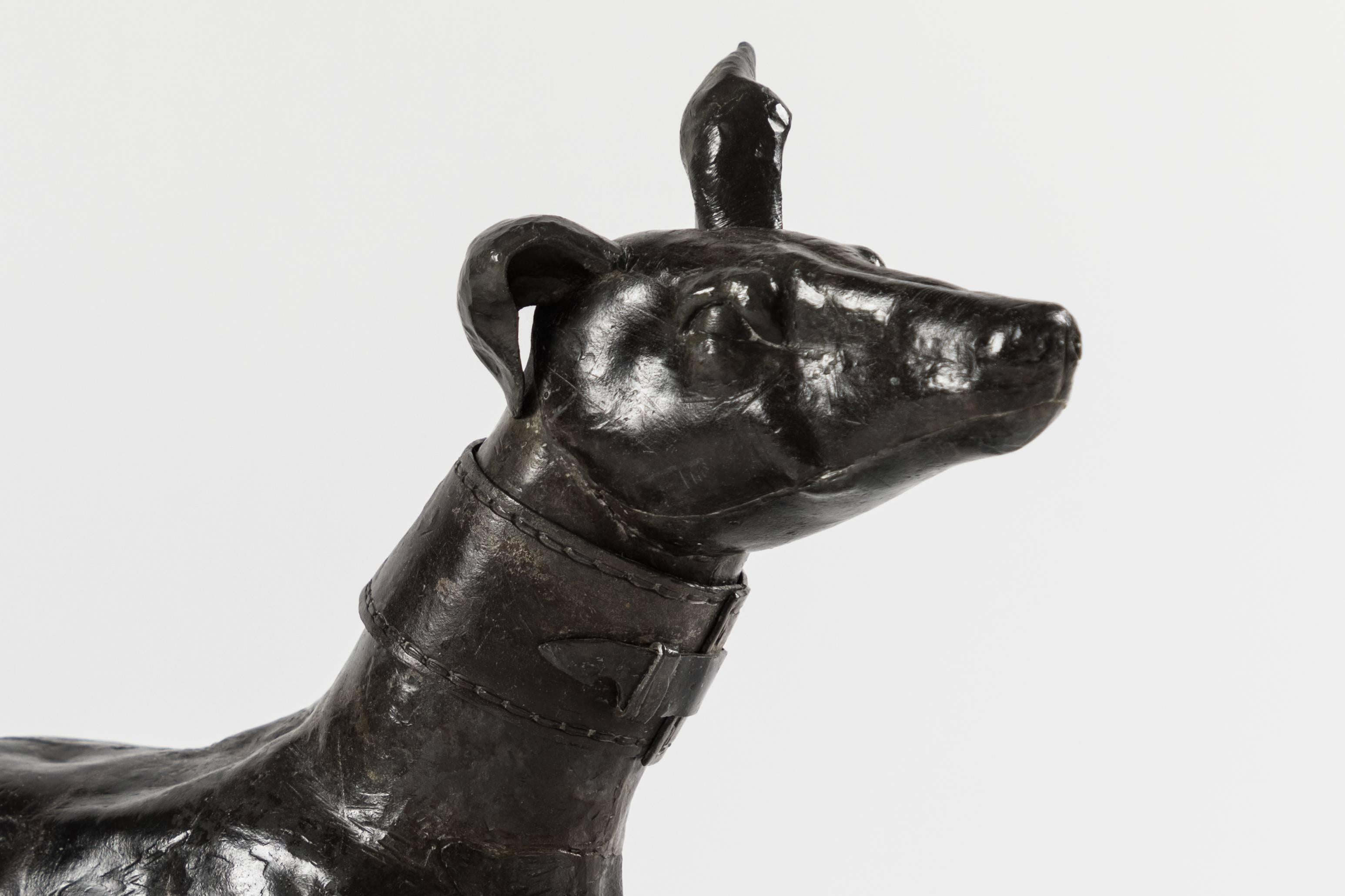 A charming Lead alloy greyhound depicted in a classic reclining position. The collar is nicely detailed and is separate from the dog casting. This little dog has a wonderful patina.