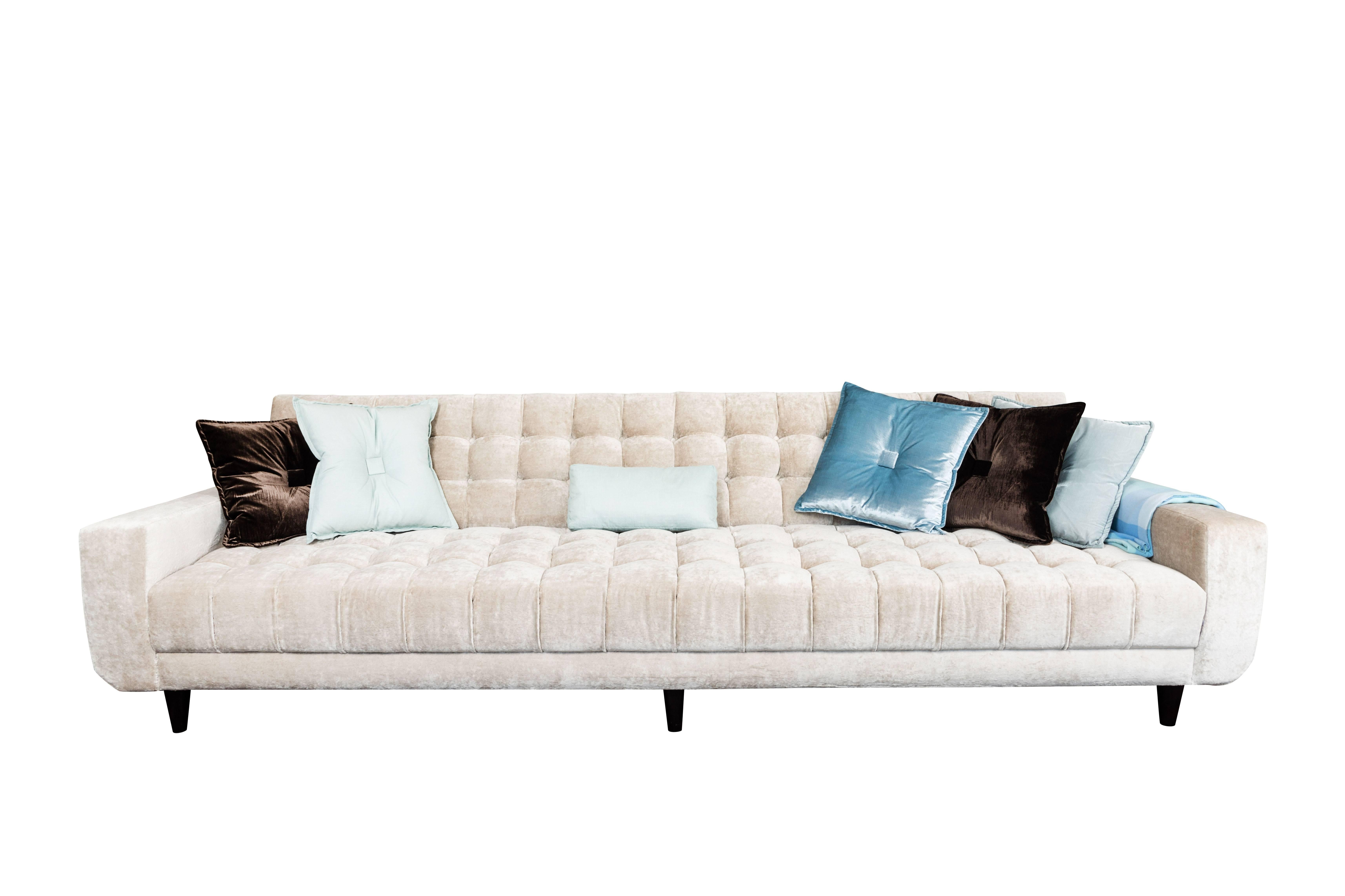 A classic example of the work of William Haines this sofa is extra long. All the important Haines details are present, the deep biscuit tufts, the ledge back, the radius front corners, and the simple conical feet. Built for with a seat depth of 24