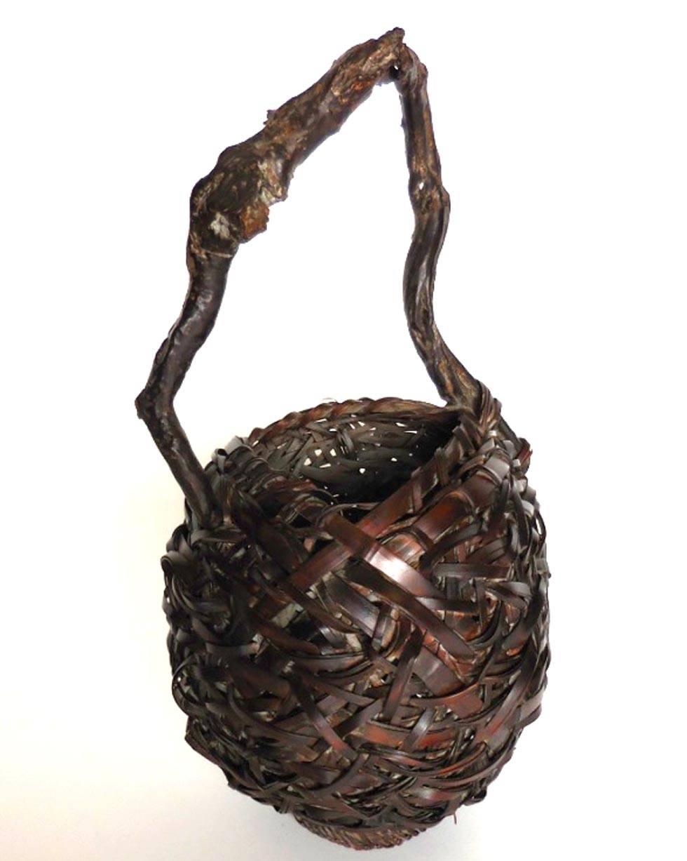Take (bamboo) Kagu (basket) for Ikebana (Japanese flower arranging). 
This woven basket has a smoked root bamboo wood vine handle. Meiji period (1868-1890).