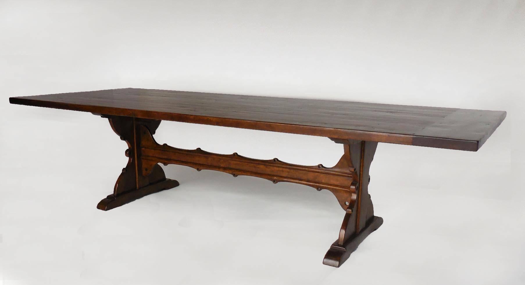 Custom 10' walnut dining table with carved trestle. Based on an antique Spanish monastery table. Large 24 inch overhang on each side created ample space for chairs. Top has breadboards on each end. Great finish. Beautiful table! Can be made in any