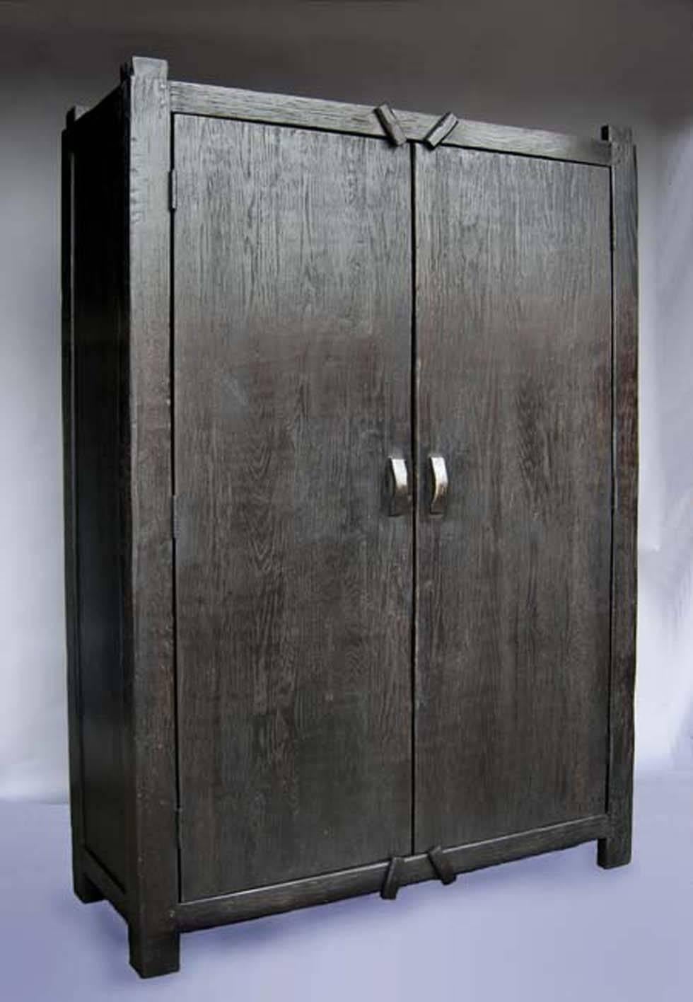 Large-scale, simple, cabinet with clean lines. Doors are flush with frame. Rustic wood latches. Striking piece with open grain wood, beautiful dark finish. 
As shown in Oak with an ebony finish. Can be made in any size and with any inside