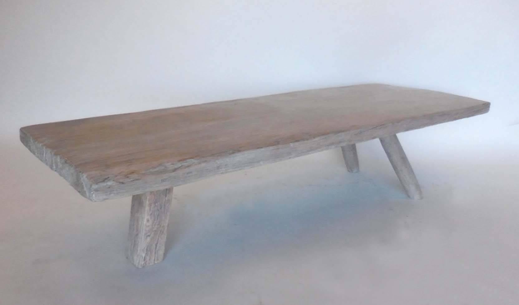 19th century, one wide wood plank sitting atop three legs. One leg is rectangular and the others are cylindrical. Nice pale white waxed finish. Antique, hand hewn surface, very smooth natural patina.