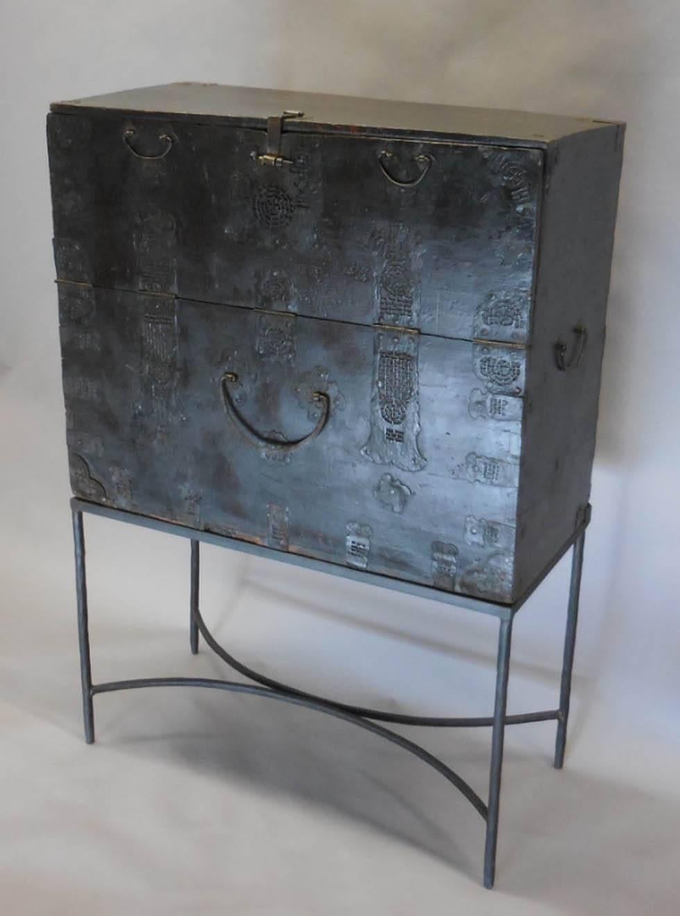 Pair of 18th Century Korean Chests.   Intricate metal cutout work decorates the pieces.  Some metal repairs have been made is the distant past. Top front panel drops down for storage.  Primitive, modern decorative pieces atop custom metal bases. The