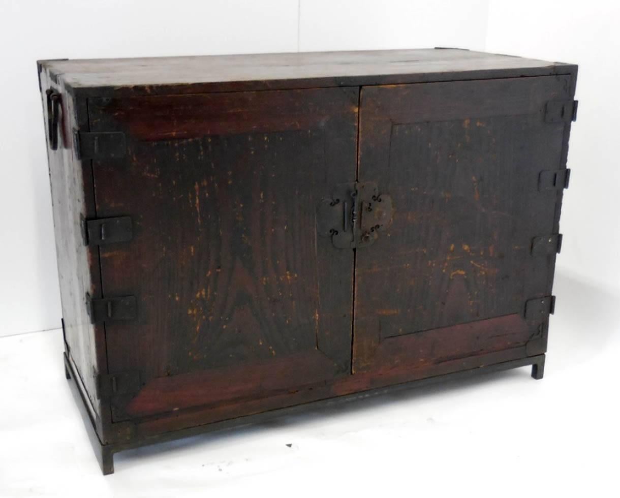 Japanese 18th century chest with beautiful original iron hardware. Two doors open revealing five interior drawers. Interior drawers are in excellent condition. Cabinet shows wear but is still very handsome. 
Sits atop custom hand forged iron base.