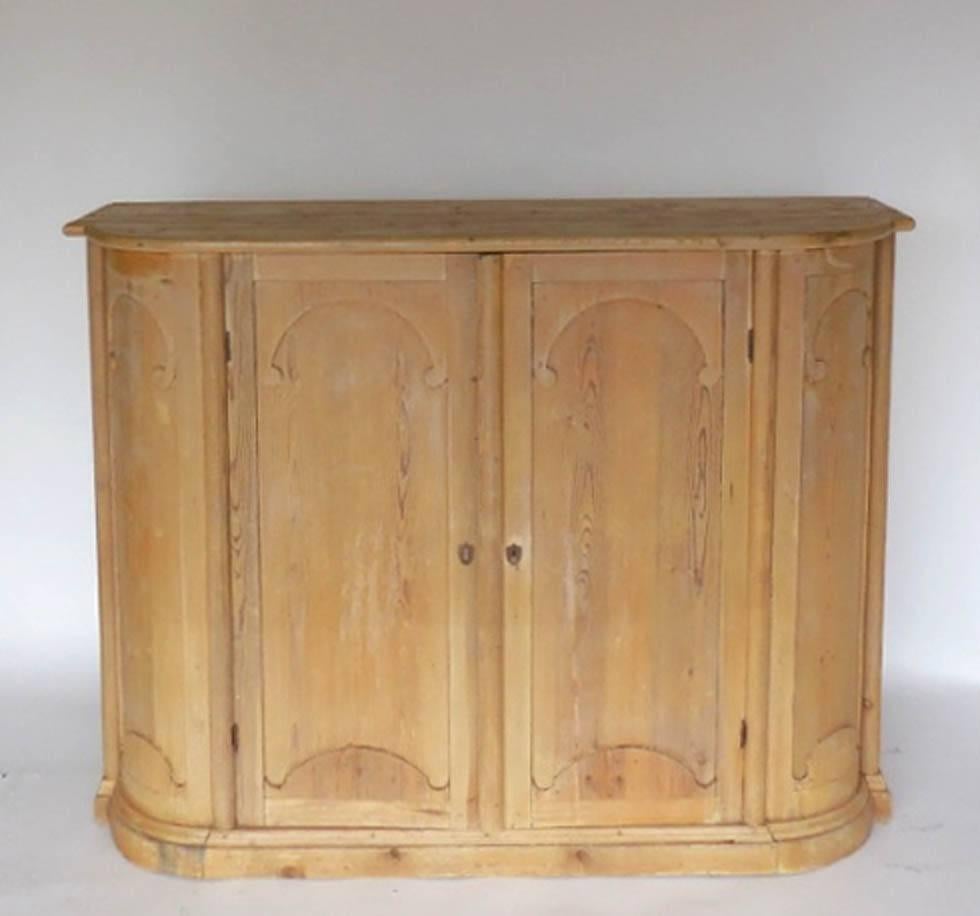 Tall Gustavian pine cabinet with curved front and curved moldings with a beautiful natural worn patina. Cabinet is from Northern Sweden and was originally used in a kitchen of a large farm house. Interior shelves. Early to mid-1800s. Wooden nails in