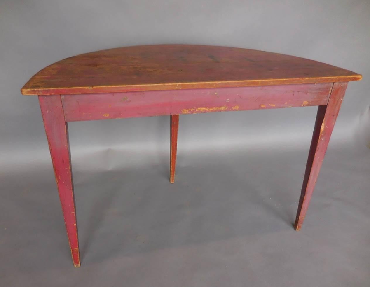 Late 19th century painted demilune table with tapered legs. Naturally worn patina throughout piece. Original wooden pegs