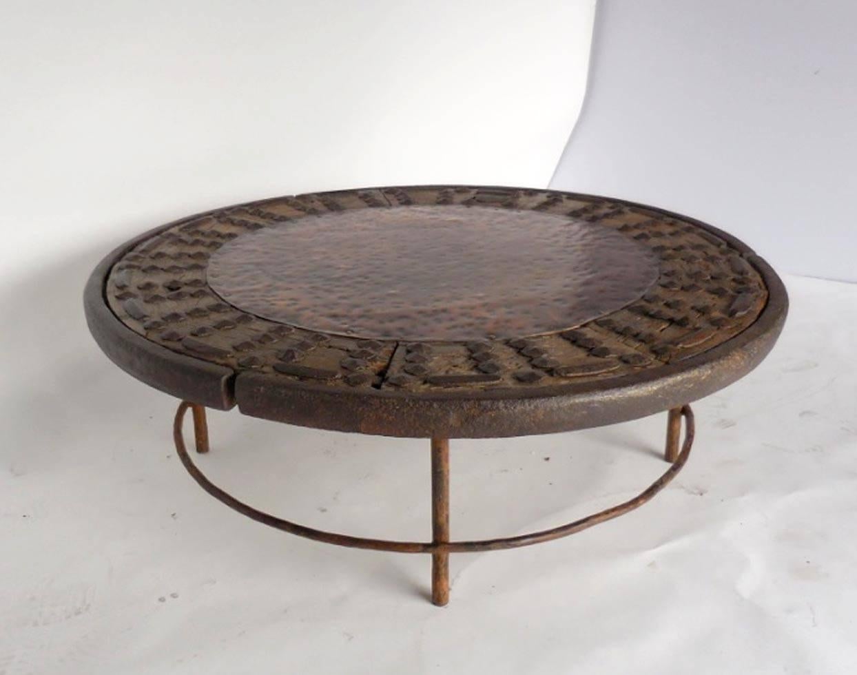 18th century Japanese iron studded, wooden wheel surrounded with iron and filled in with hammered copper. Hand-forged and hand-hammered legs. Unique table with contrasting metals and wood. y Dos Gallos Studio piece.