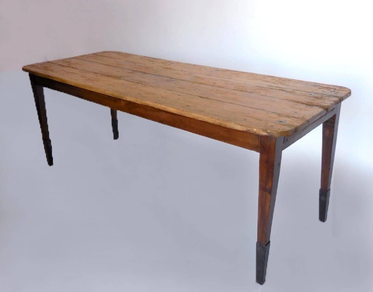 19th century New England country pine table with iron leg extensions. Short apron so there is plenty of leg room. Naturally distressed top commensurate with age and use. Elegant tapered legs.