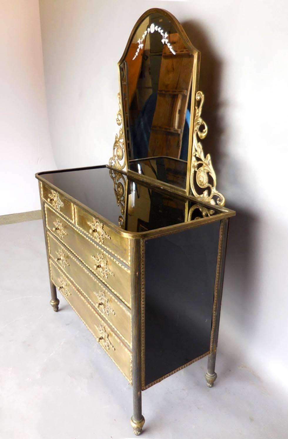 1930s unusual chest of drawers. Top and sides are black glass. Etched vanity mirror and decorative cornices are removable. Gold tone metal drawer fronts. Elaborate pulls. All original. Height without mirror is 31 H.