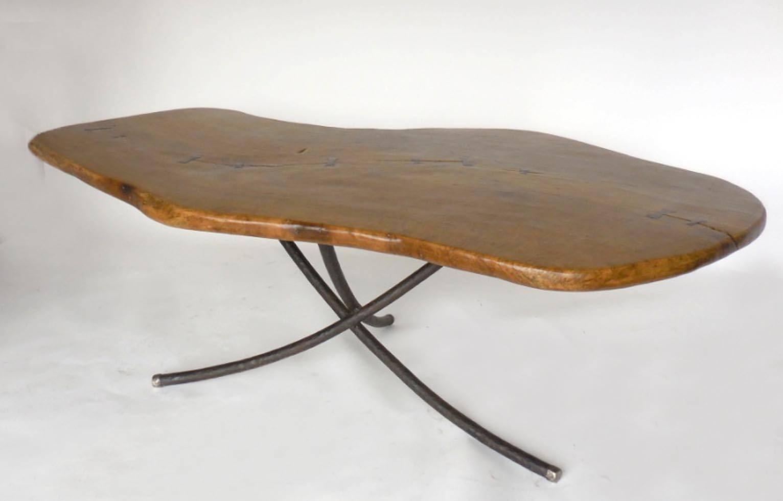 Molave, a tropical hardwood, table in an organic shape with contrasting dark wood butterfly repairs along top. Wood is beautifully burled in a rich wood tone. The base is constructed of hand-forged, hand-hammered iron legs with pewter tips. Can be
