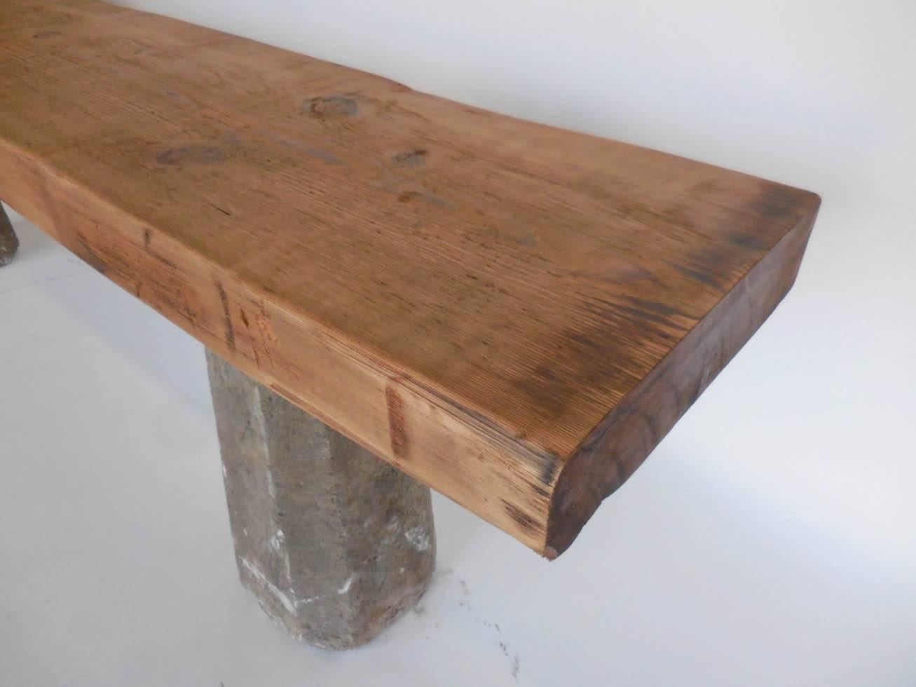 Reclaimed wood beam atop 19th century tapered stone bases from Guatemala. Wood and stone both show natural wear and patina. Sturdy and strong architectural piece. Top is smooth to the touch.