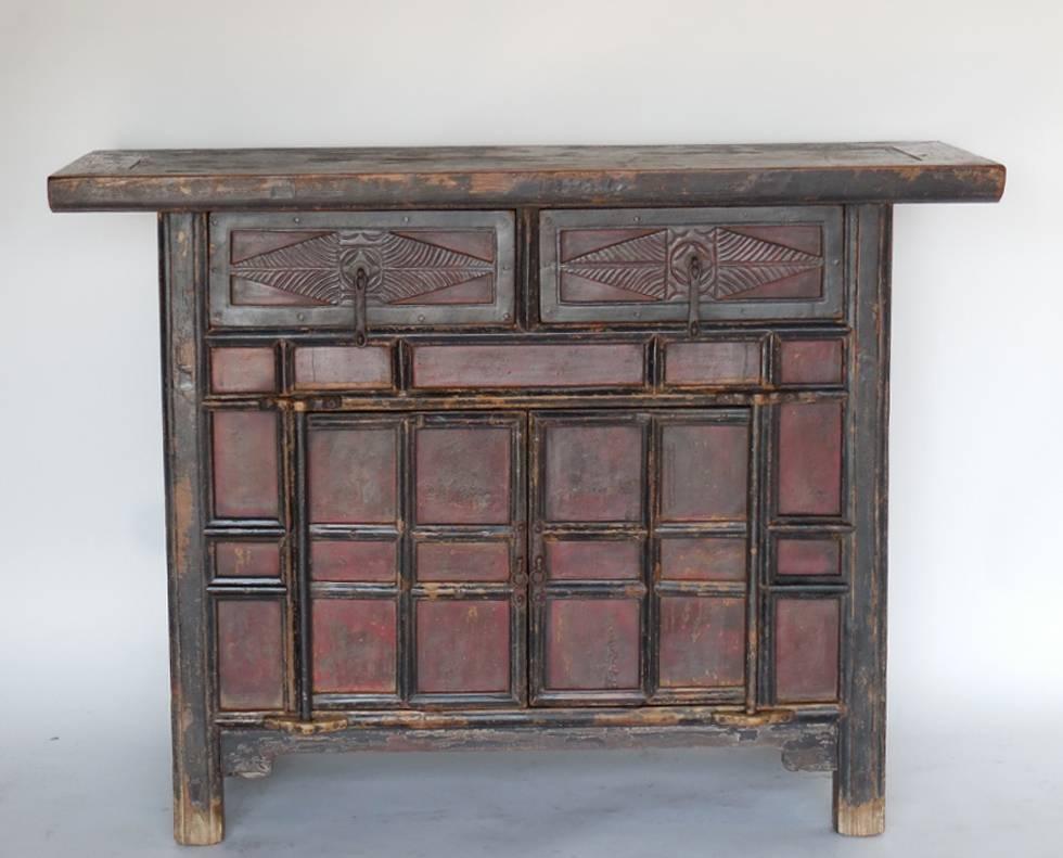 All original 18th century Qing dynasty cabinet with two carved drawers with original wrought iron hardware atop a two door cabinet. Doors swing on wooden hinges. Bamboo nails, mortise and tenon construction and dove tailed drawers. Original black