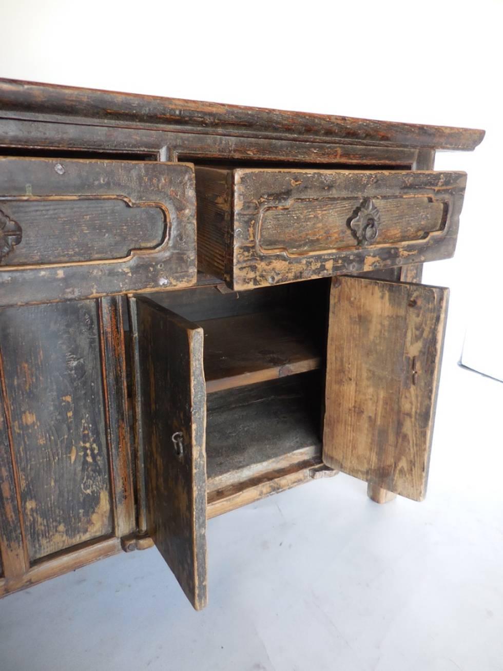 Qing dynasty coffer. Three large drawers and bottom storage area with doors. Old black worn paint. Carved wood rosettes. Wooden hinges. In very good condition for its age, all original with dovetailed drawers. Interior shelf added later. Back is