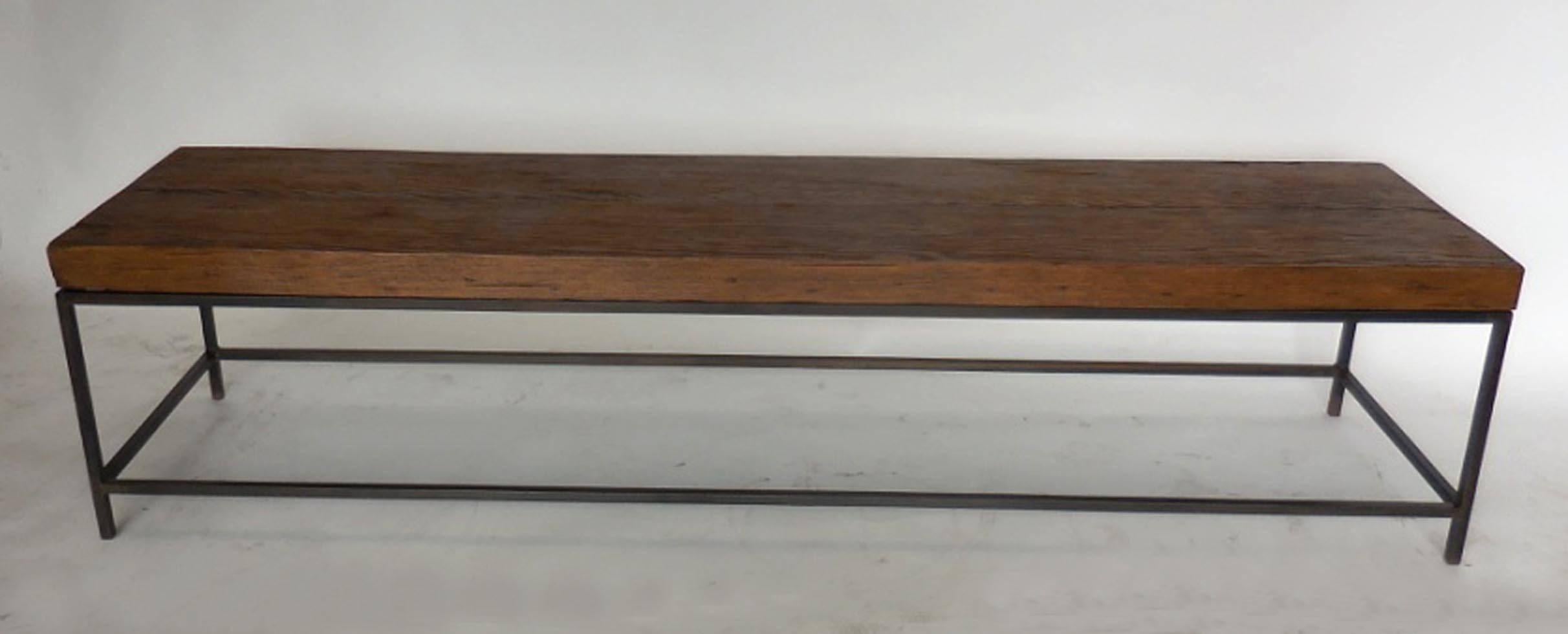 Rustic, yet modern bench or coffee table made from reclaimed wood atop and a hand-forged iron base. Can be made in any size in a variety of finishes. Made in Los Angeles by Dos Gallos Studio.