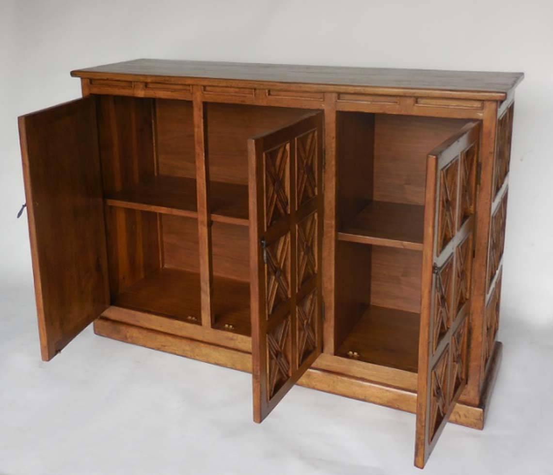 Custom console or cabinet, with three doors and interiors shelves. Can be made in any configuration, size and finish and in a variety of woods. Shown here in Walnut with a medium distress and light walnut finish. Iron clavos, large nail heads, and