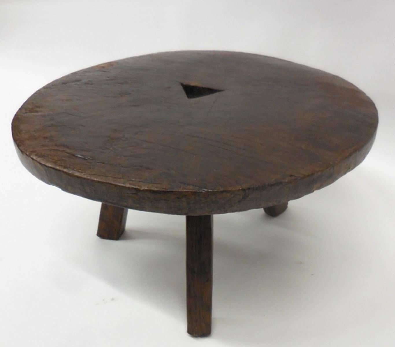 19th century wooden wheel, transformed onto a three legged stool/ side table. Triangular cut-out in the middle. Very sturdy and heavy. Great patina.