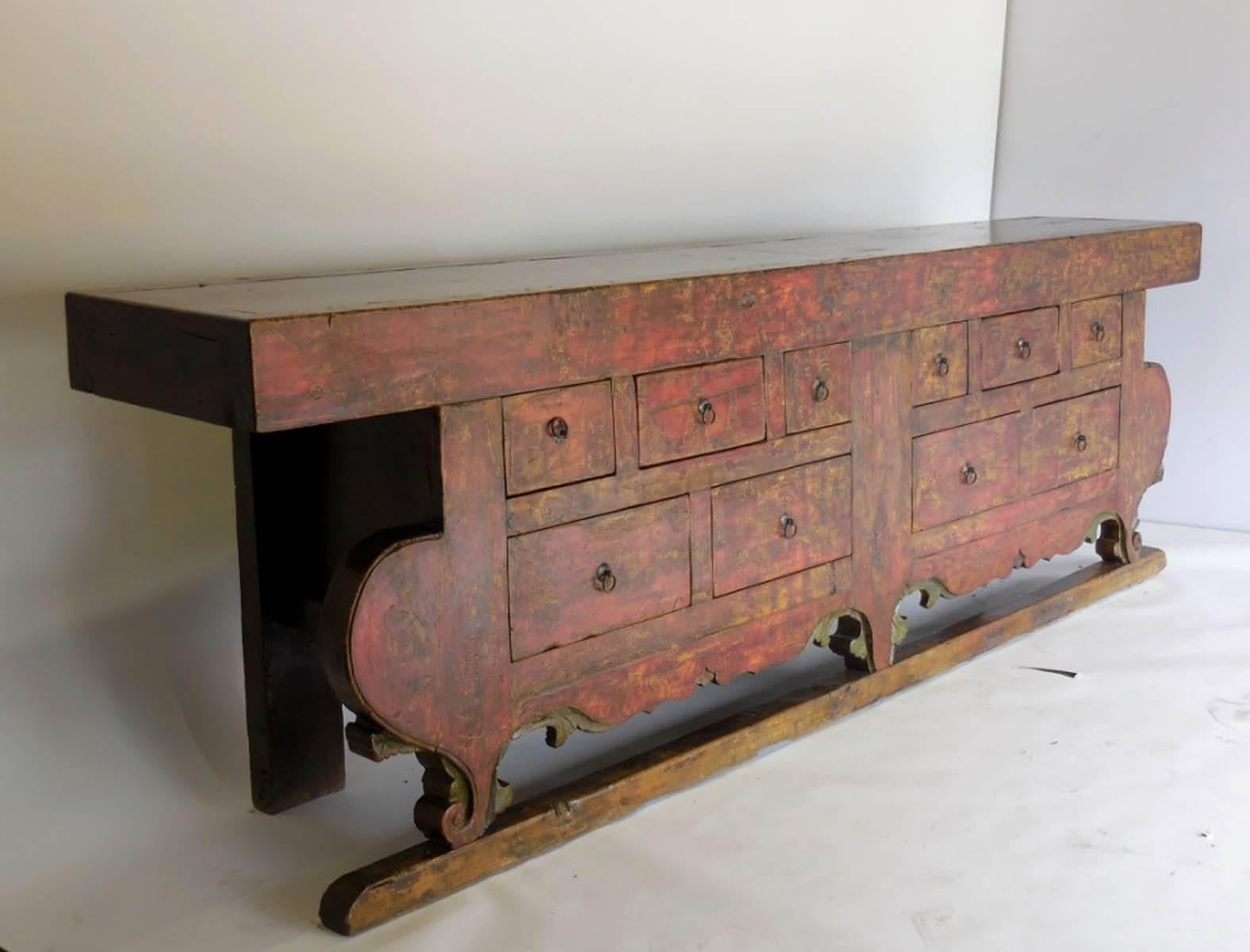 Striking, very large 18th century painted and lacquered altar table with ten fully functioning drawers. It still maintains the original red paint, gently faded through the years revealing a slight yellow undertones and is protected with a