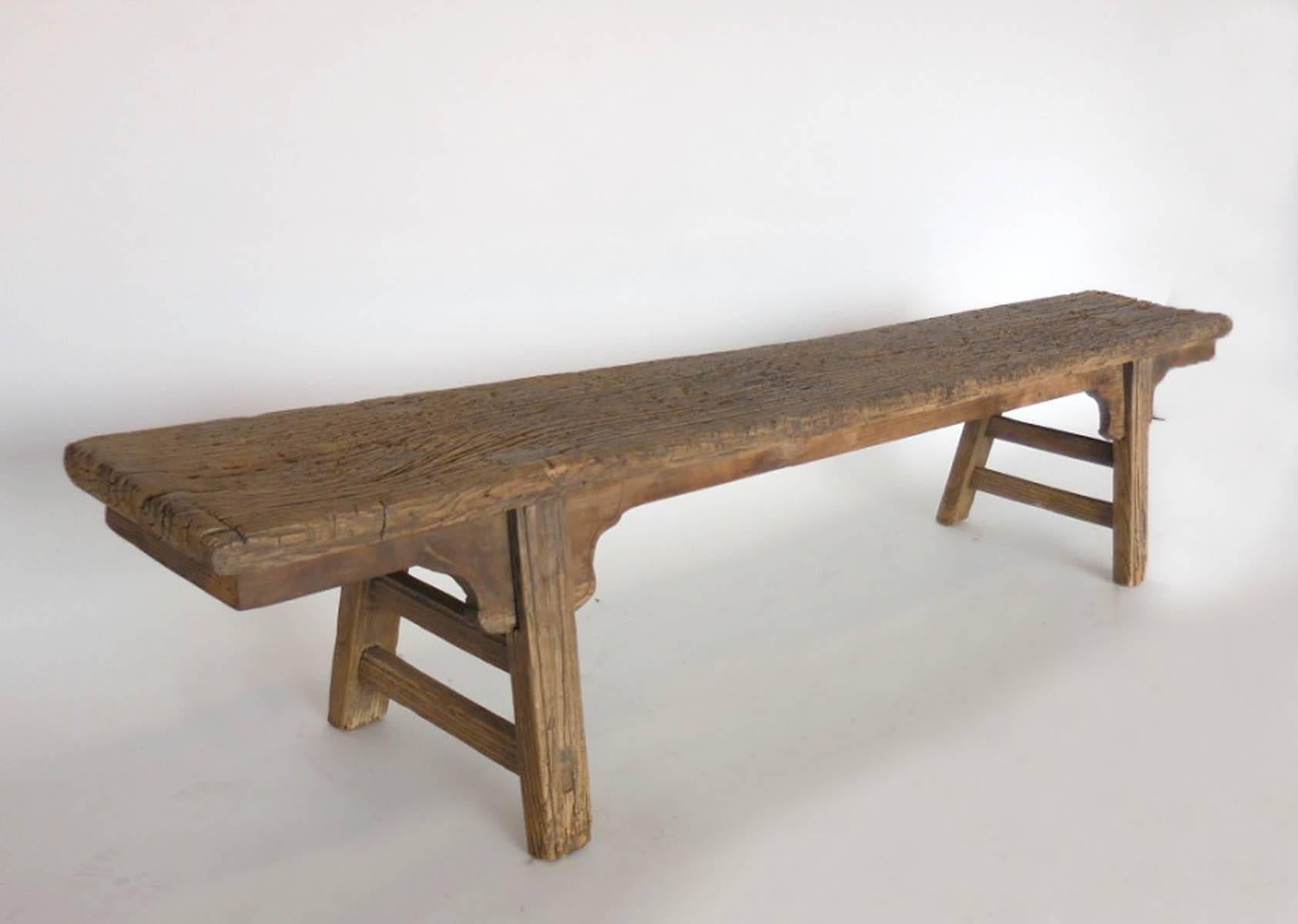 18th-19th century Chinese elm bench with dove tail construction and wooden nails. Decorative detail by legs. Rustic but delicate look. Sturdy and functional.
Weathered and smooth patina.