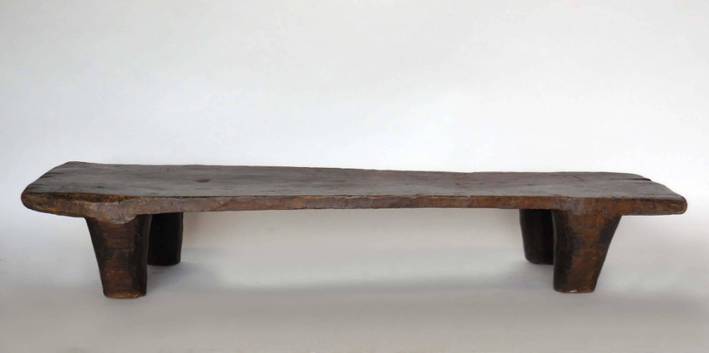 Primitive early 20th century Nupe bed for a child. Carved out of one piece of wood with conical shaped legs and a smooth flat surface on top. Measure: The height varies from 9.25 to 11.5 inches. Nupe tribe, Northern Nigeria.