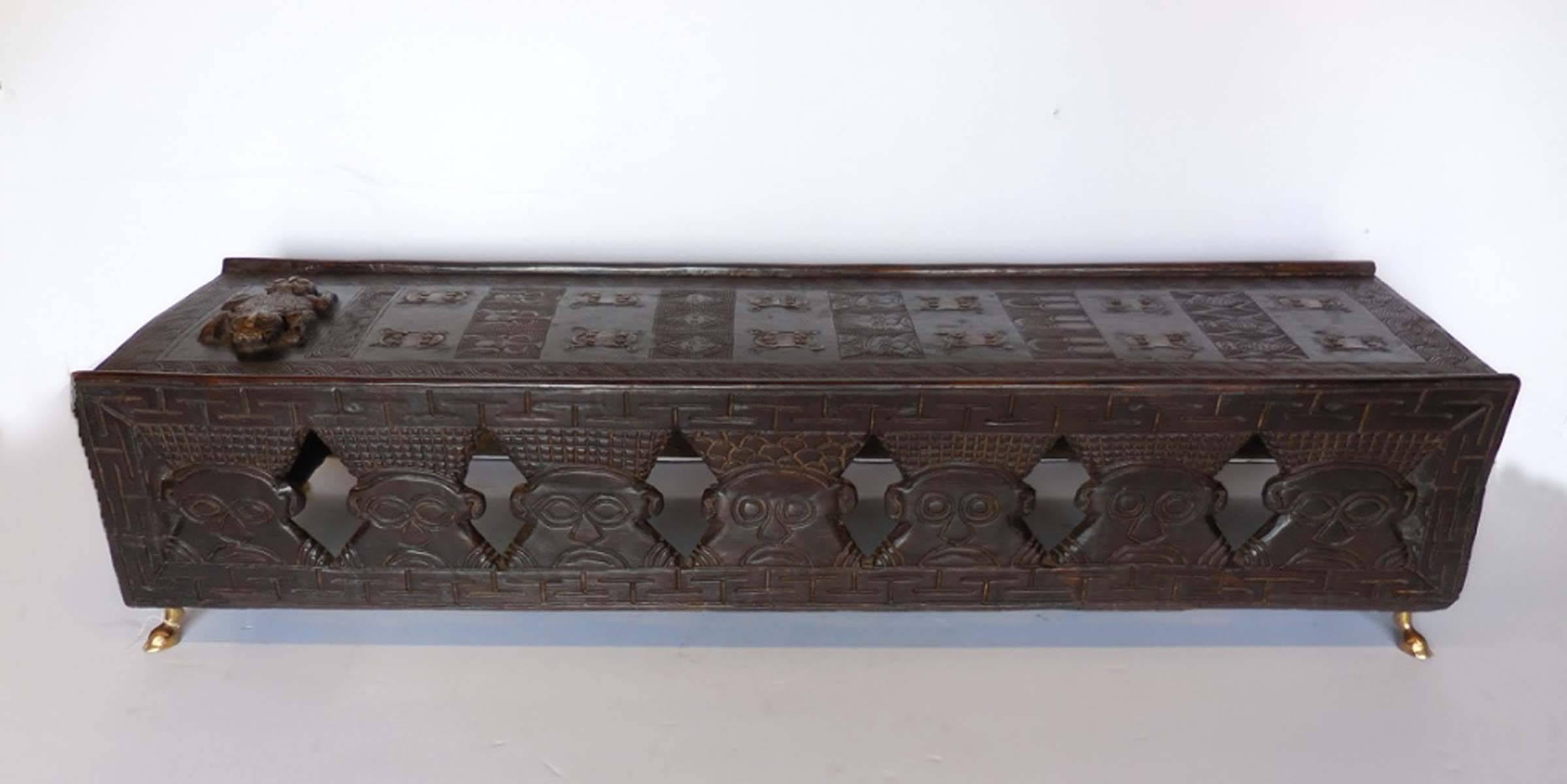 20th century hand-carved tribal bench from Cameroon. Stylized male figures and faces and bronze frogs along the top and both sides. Newer short bronze animal hoof legs. Works well as a coffee table or bench.
