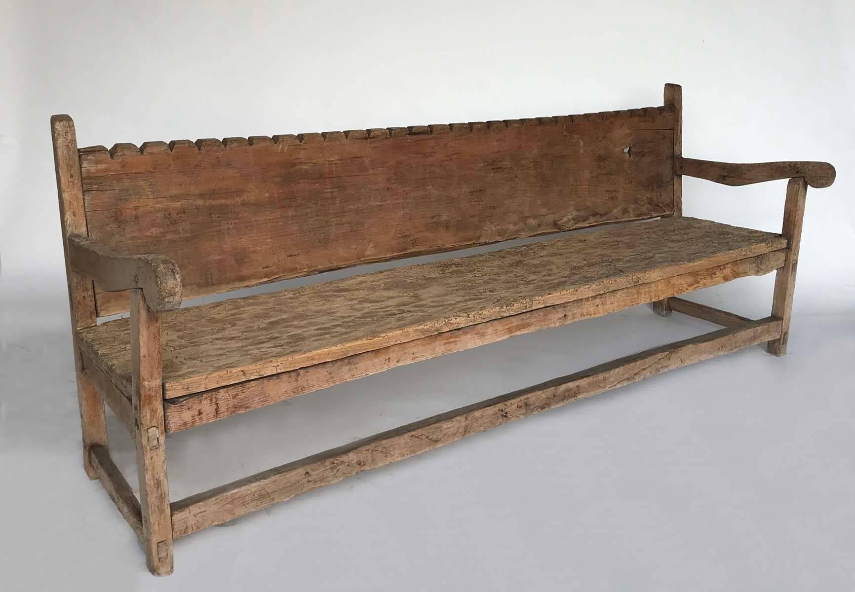 Great old Guatemalan Chajul bench with scalloped backrest. Seat and back are made of one large wide Cypress plank each. Has had a long life outside and it is worn, sun bleached and naturally showing signs of age and wear. It has a natural beauty and